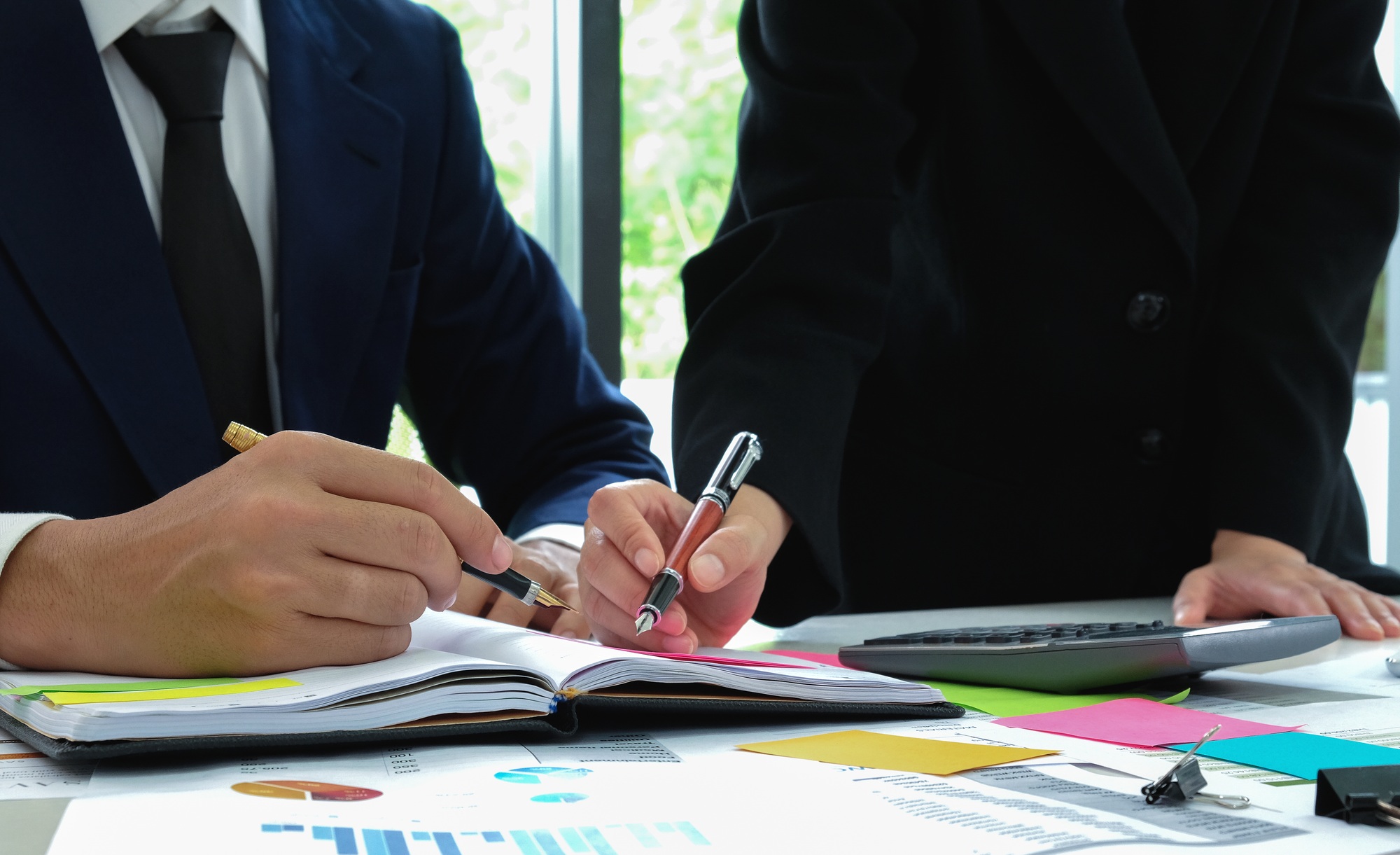 Business team analyzes data from graphs to present customers.