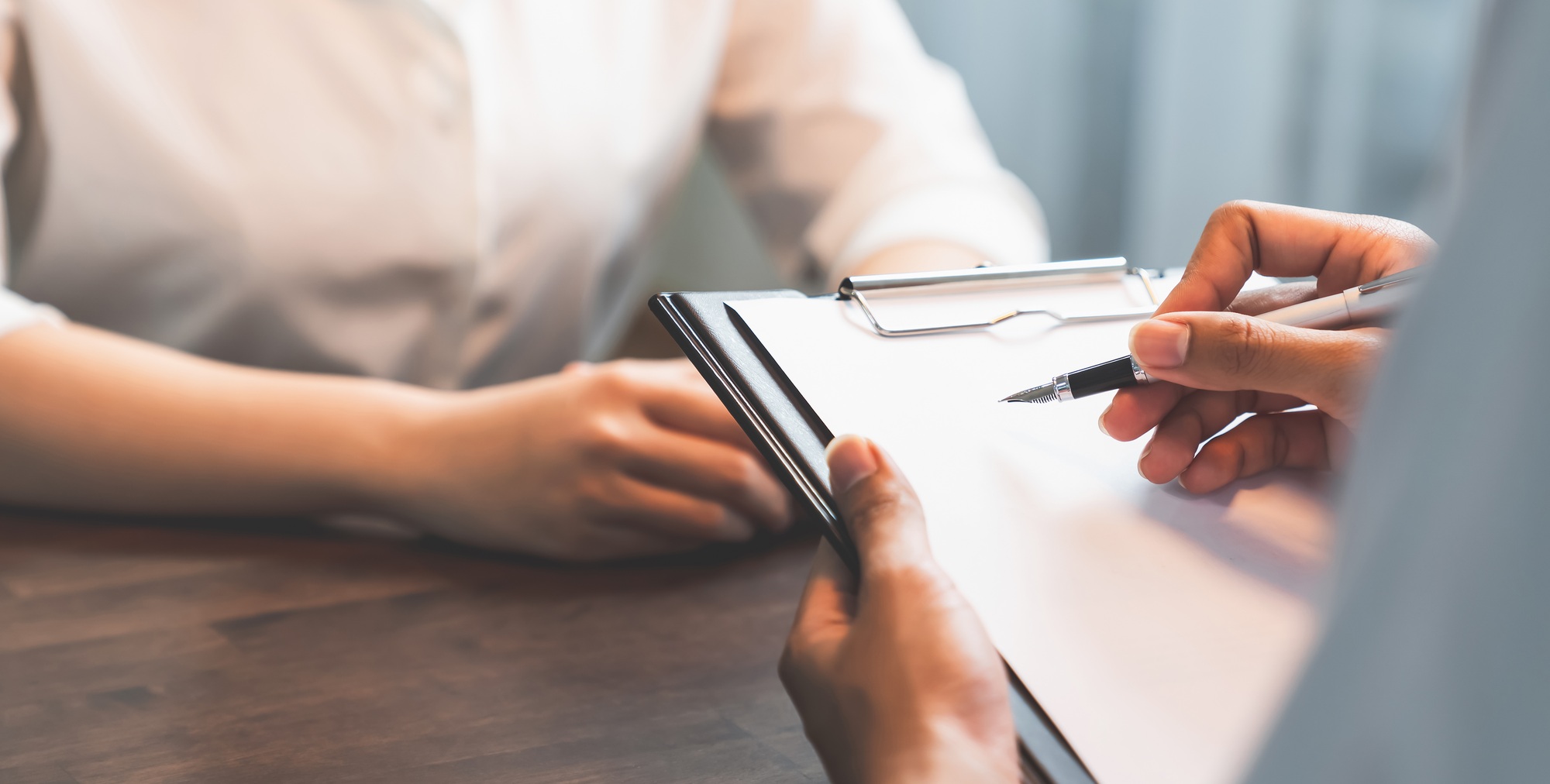 Businessman hand holding pen putting on the paper and draft contract with the customers.