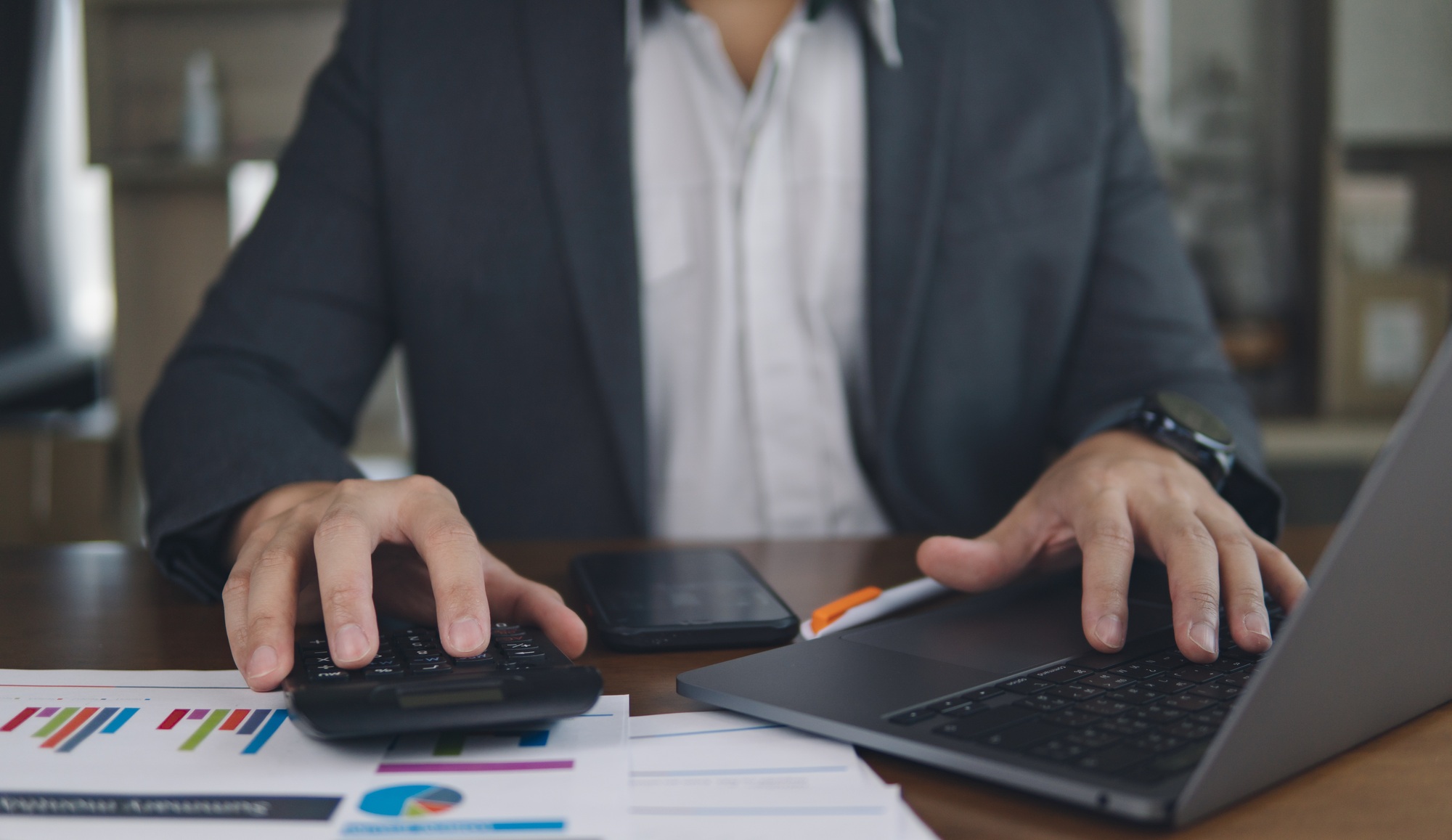 finance and accounting concept. business woman working on desk using calculator to calculate