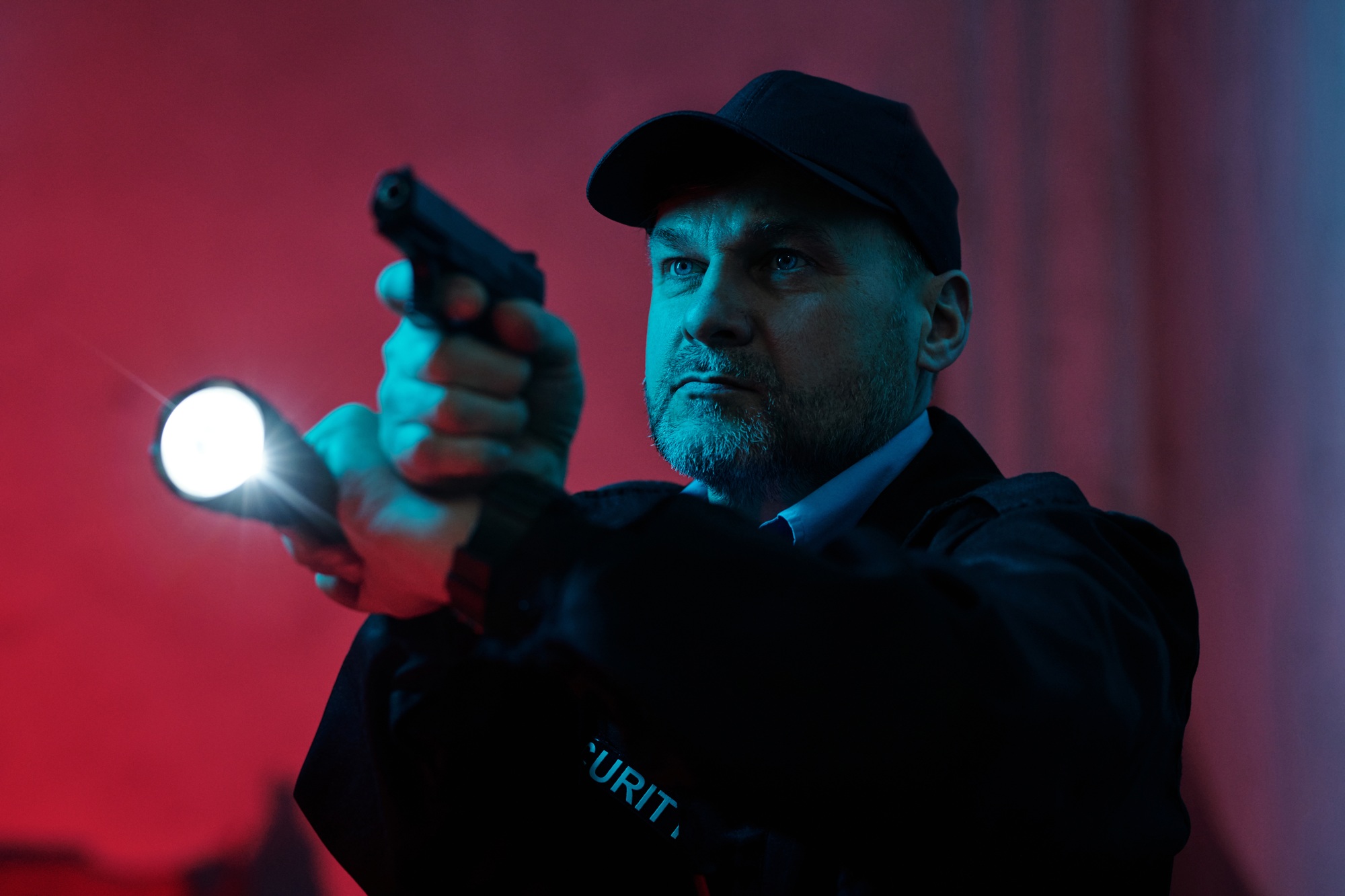 Security guard with flashlight and gun