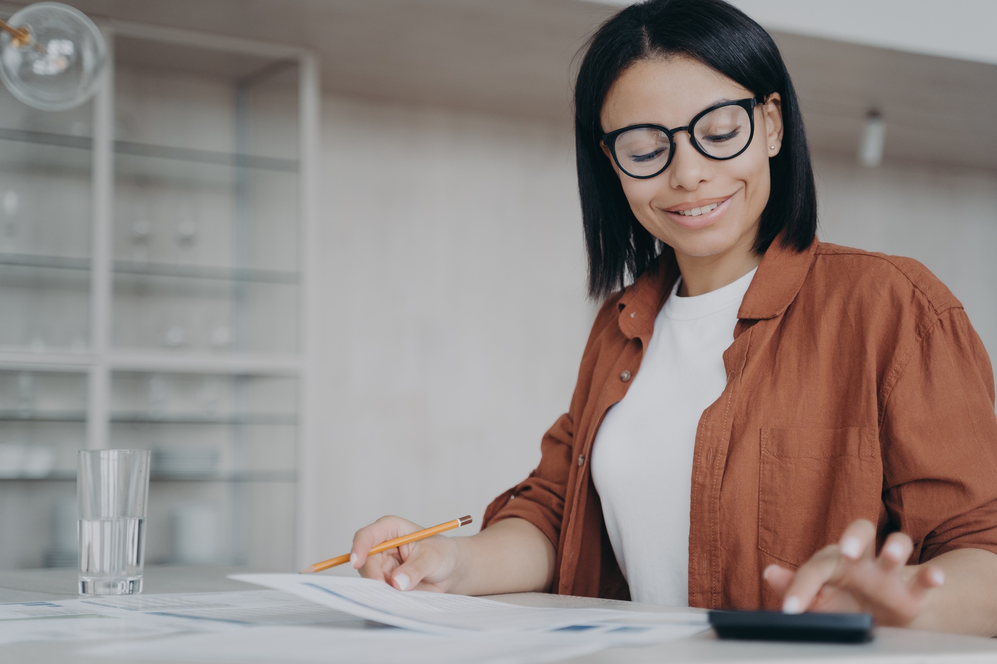 Successful mixed race businesswoman is calculating expends. Finances and investment concept.