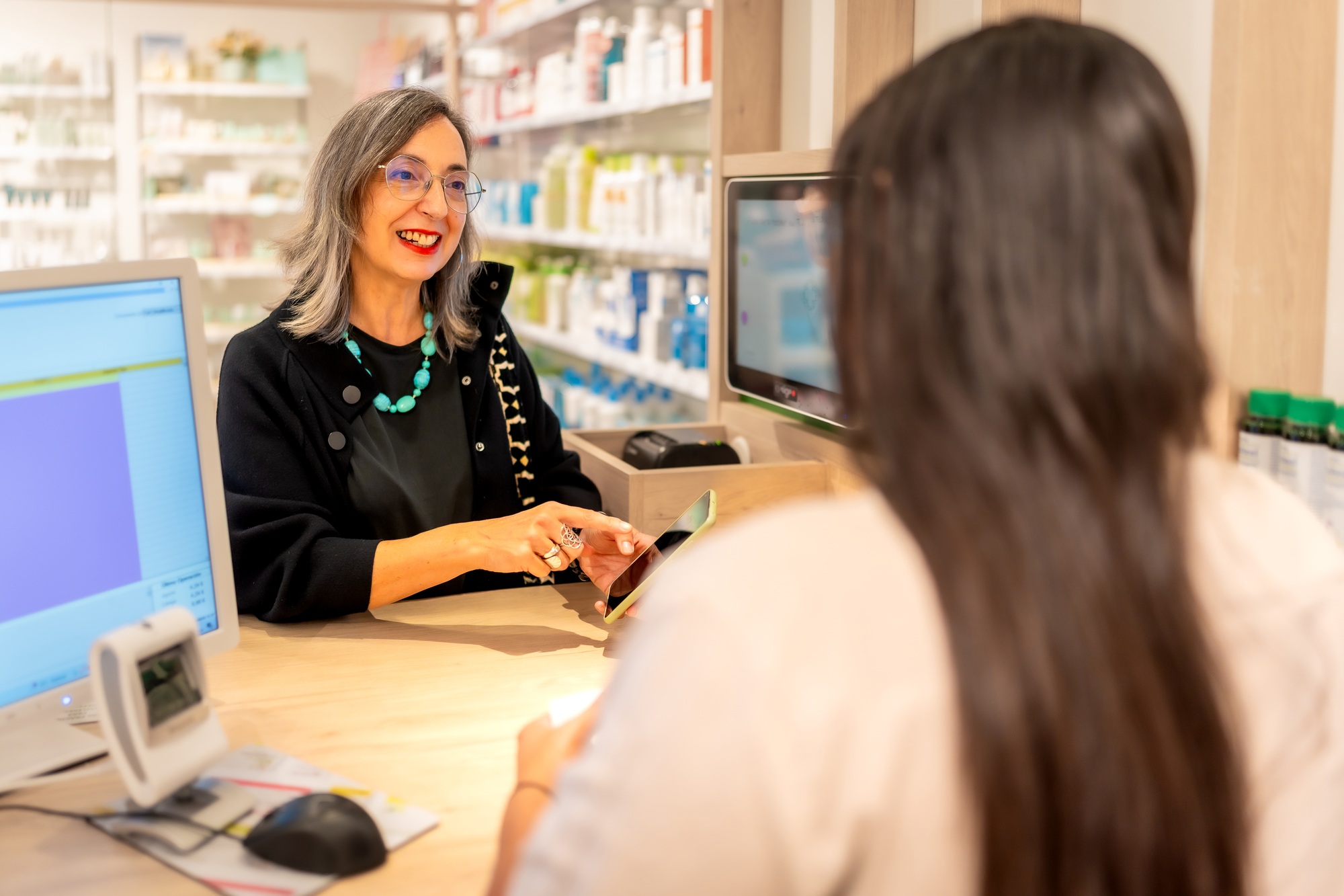 Woman using phone to show a product to a pharmacist