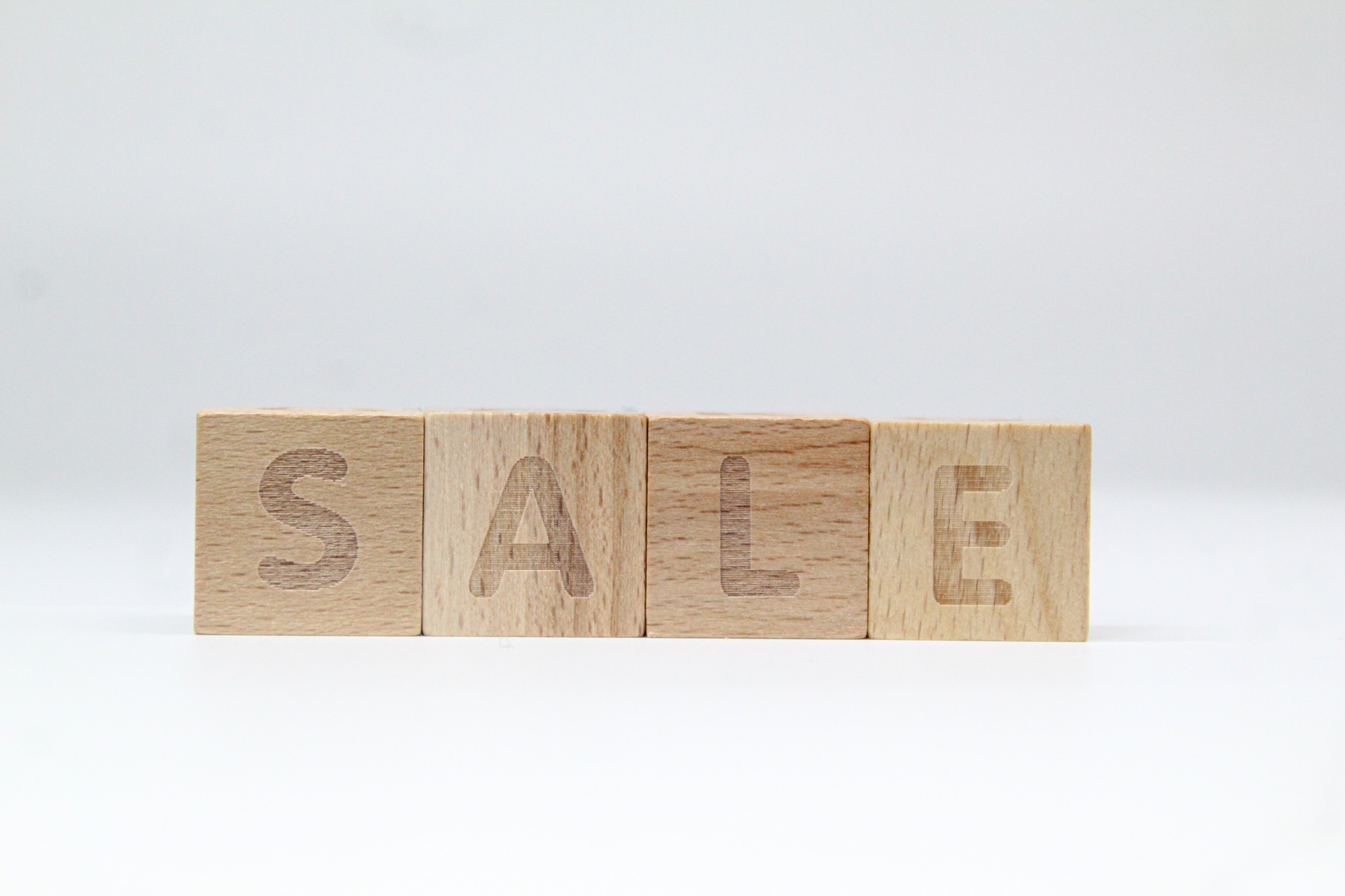 wooden cube with the word sale.