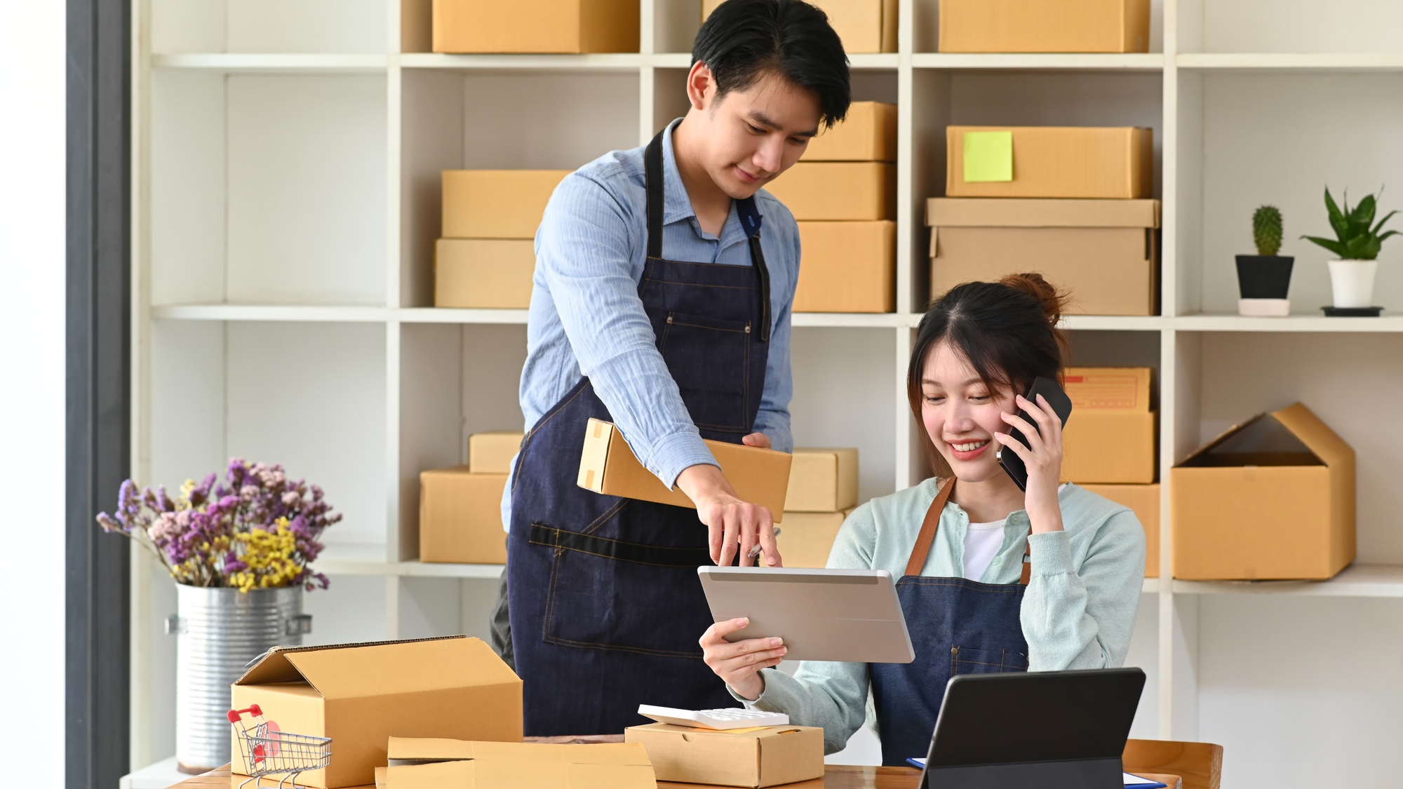 Young Asian couple starting their own small business at home office.