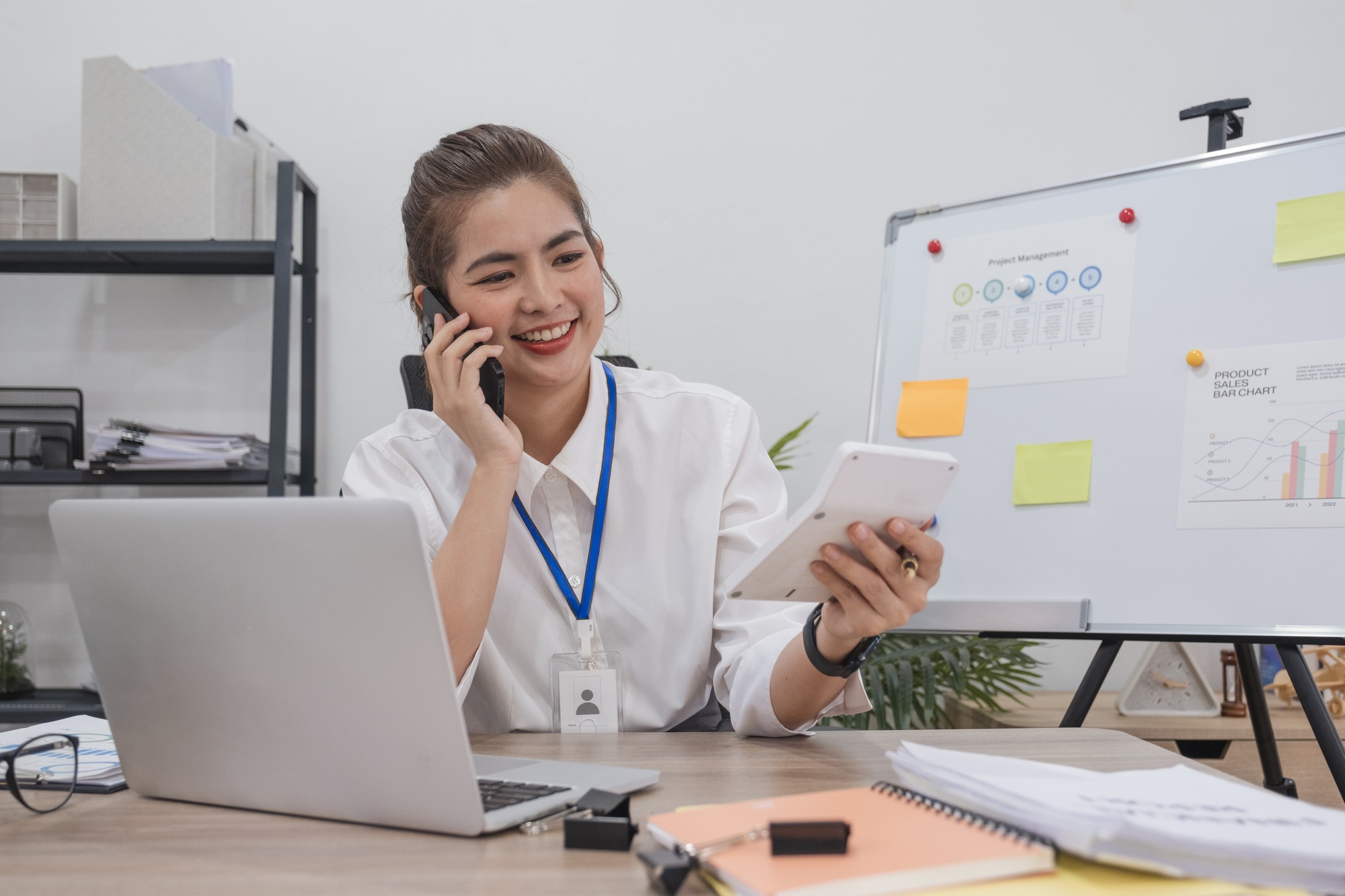 Young businesswoman uses the phone to talk with customers in business planning, business management.
