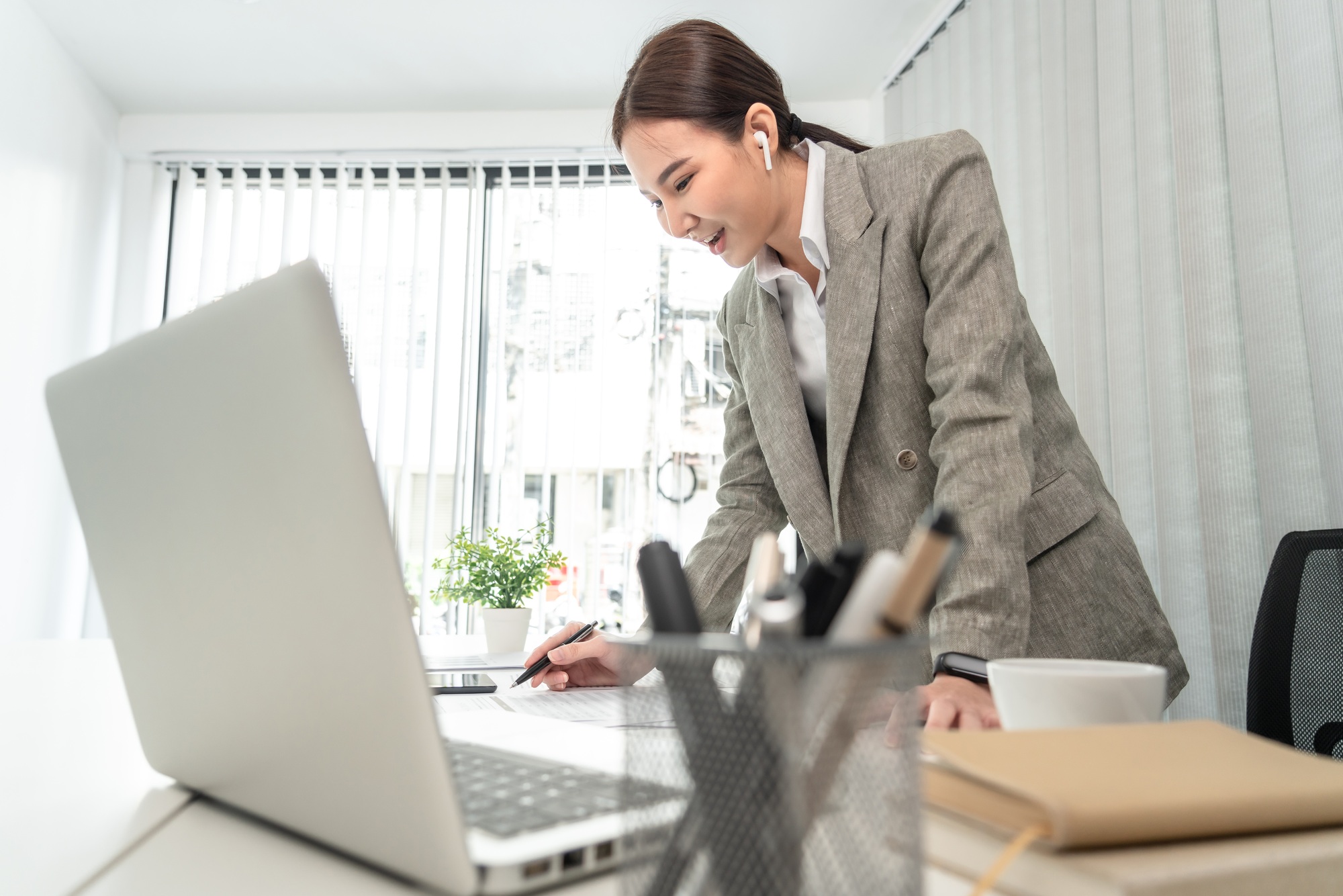 Asian business women are analyzing company sales statistical graphs to develop them further