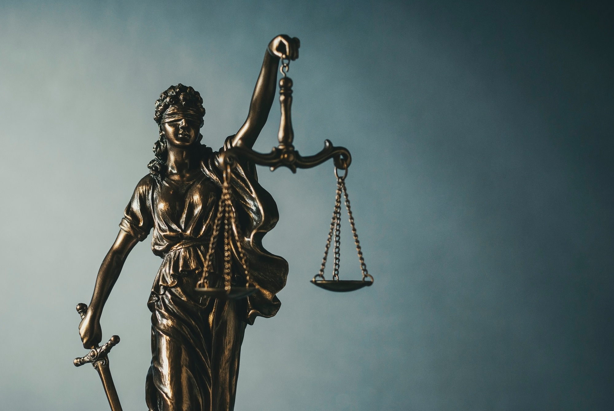 Brass statue of Justice holding scales and sword