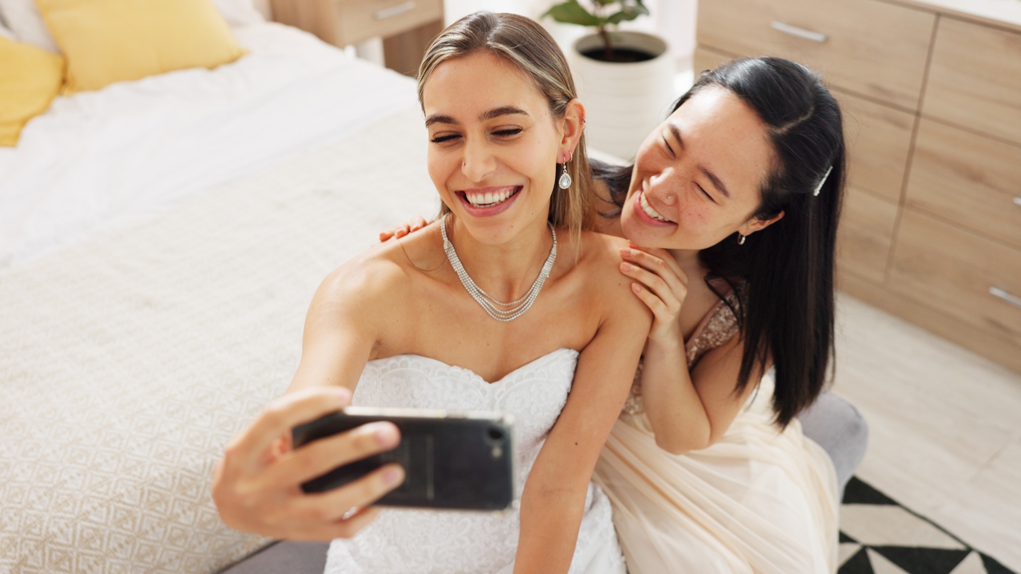 Bride, bridesmaid and selfie with phone, wedding and ring with a smile to post on social media. Hap