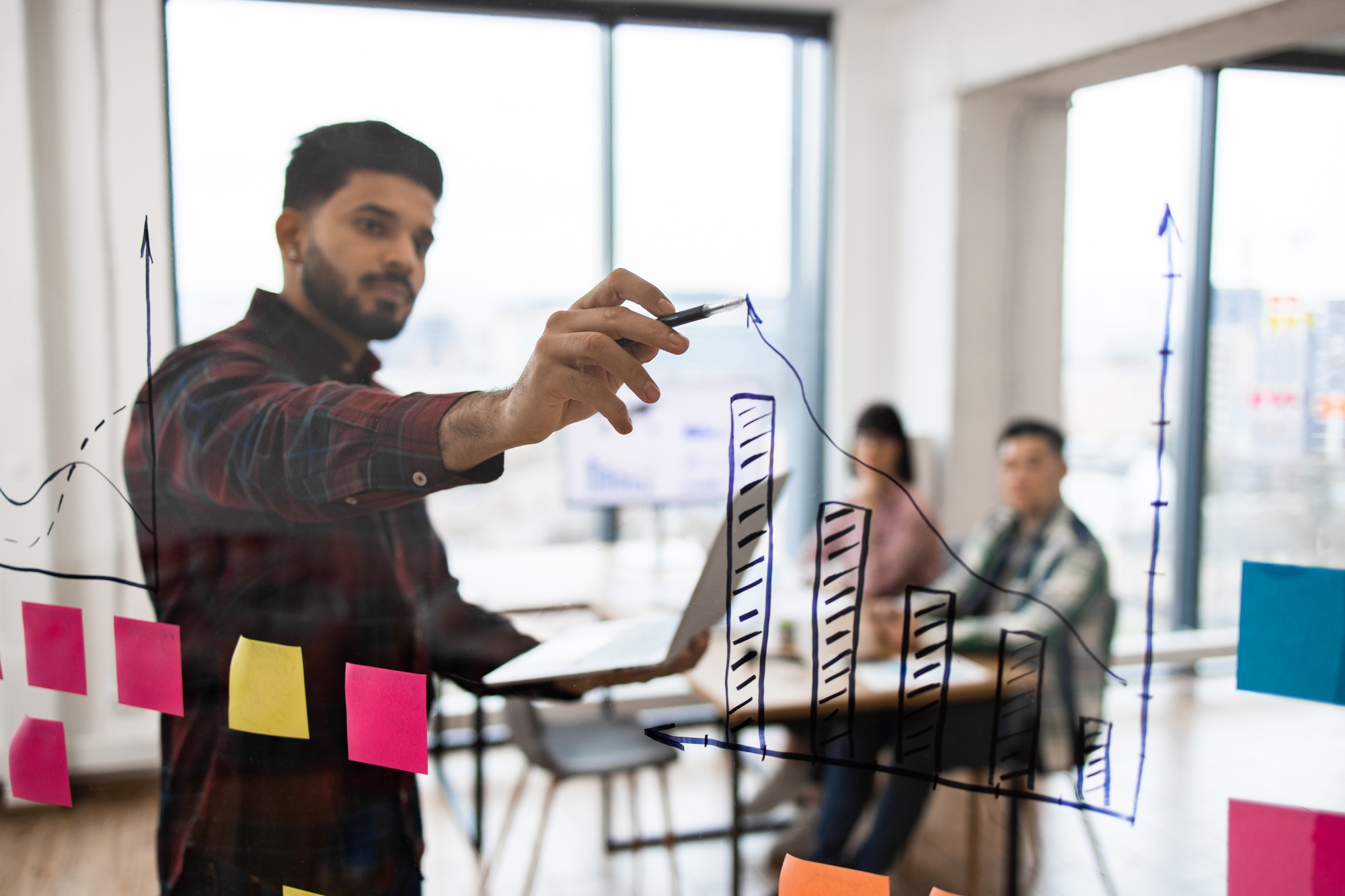 Business meeting with data analysis on transparent board
