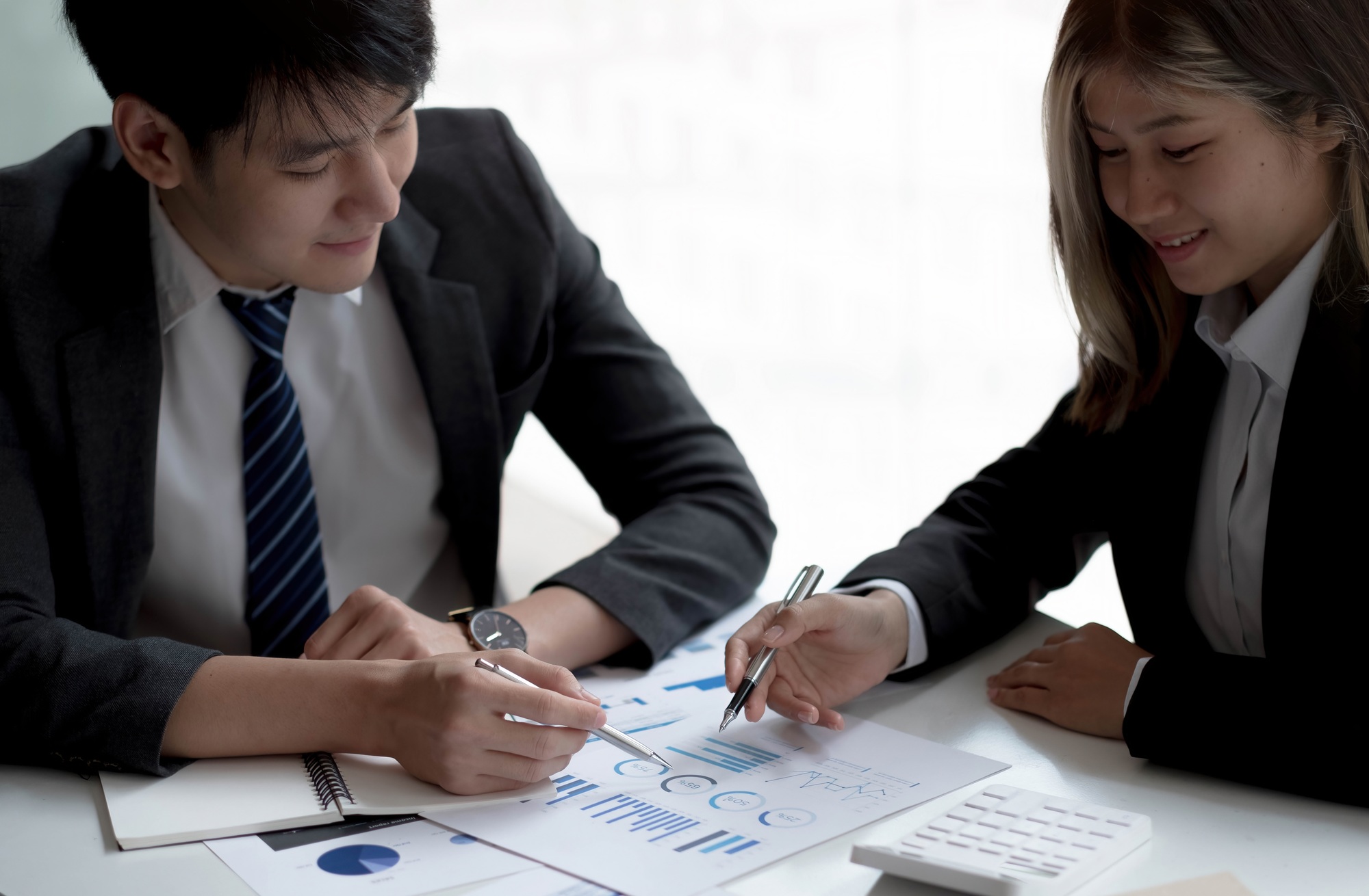 Business people meeting to find analytical ideas pointing to the graph at the office.