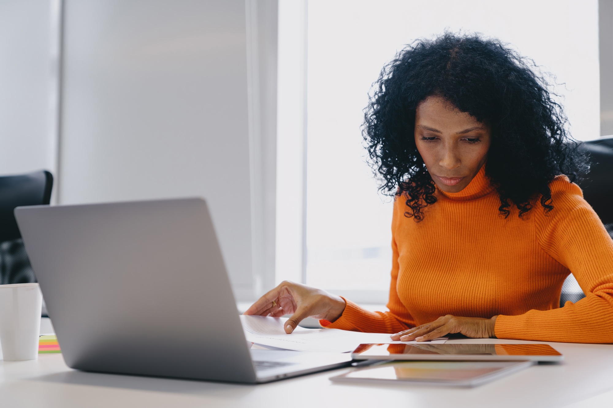 Concentrated African American entrepreneur in her 30s reviewing business analytics on a tablet
