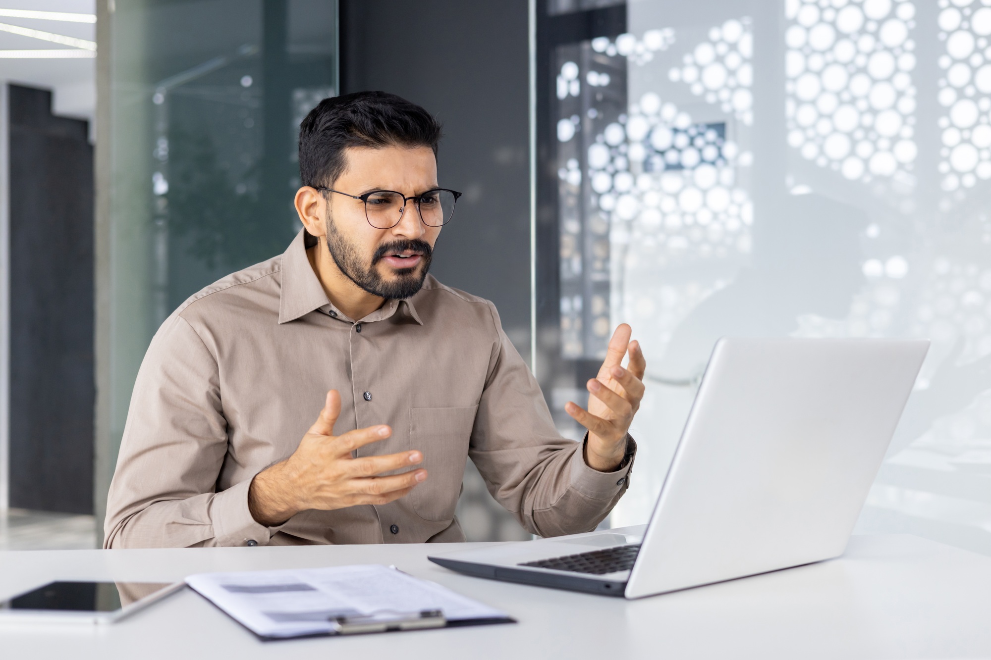 Confused Indian businessman discussing issues at workplace