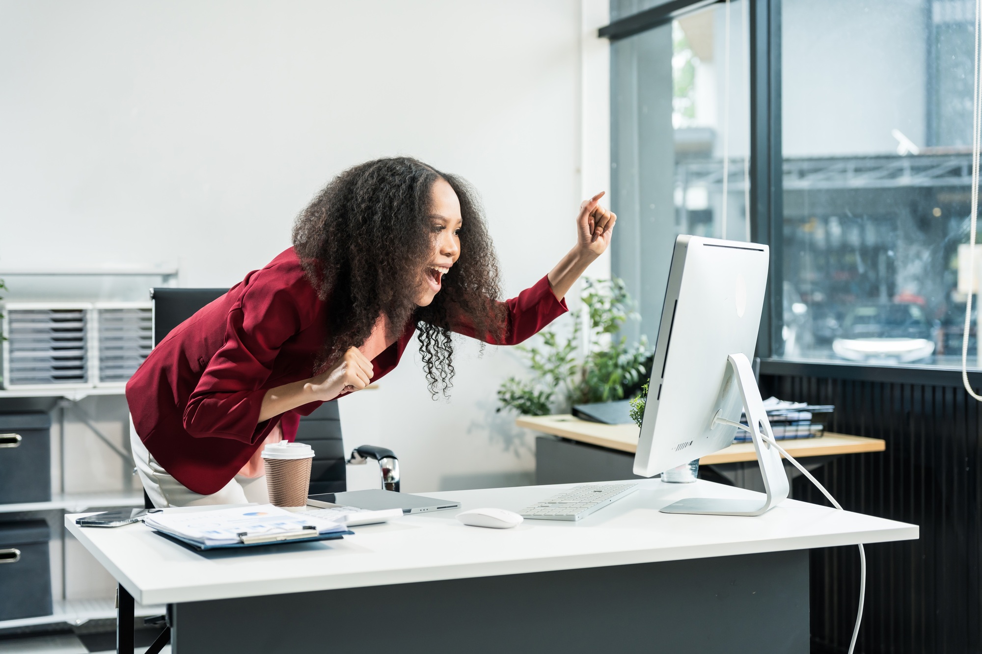 African American woman with afro at desk, managing finance, market research, investors for startup.
