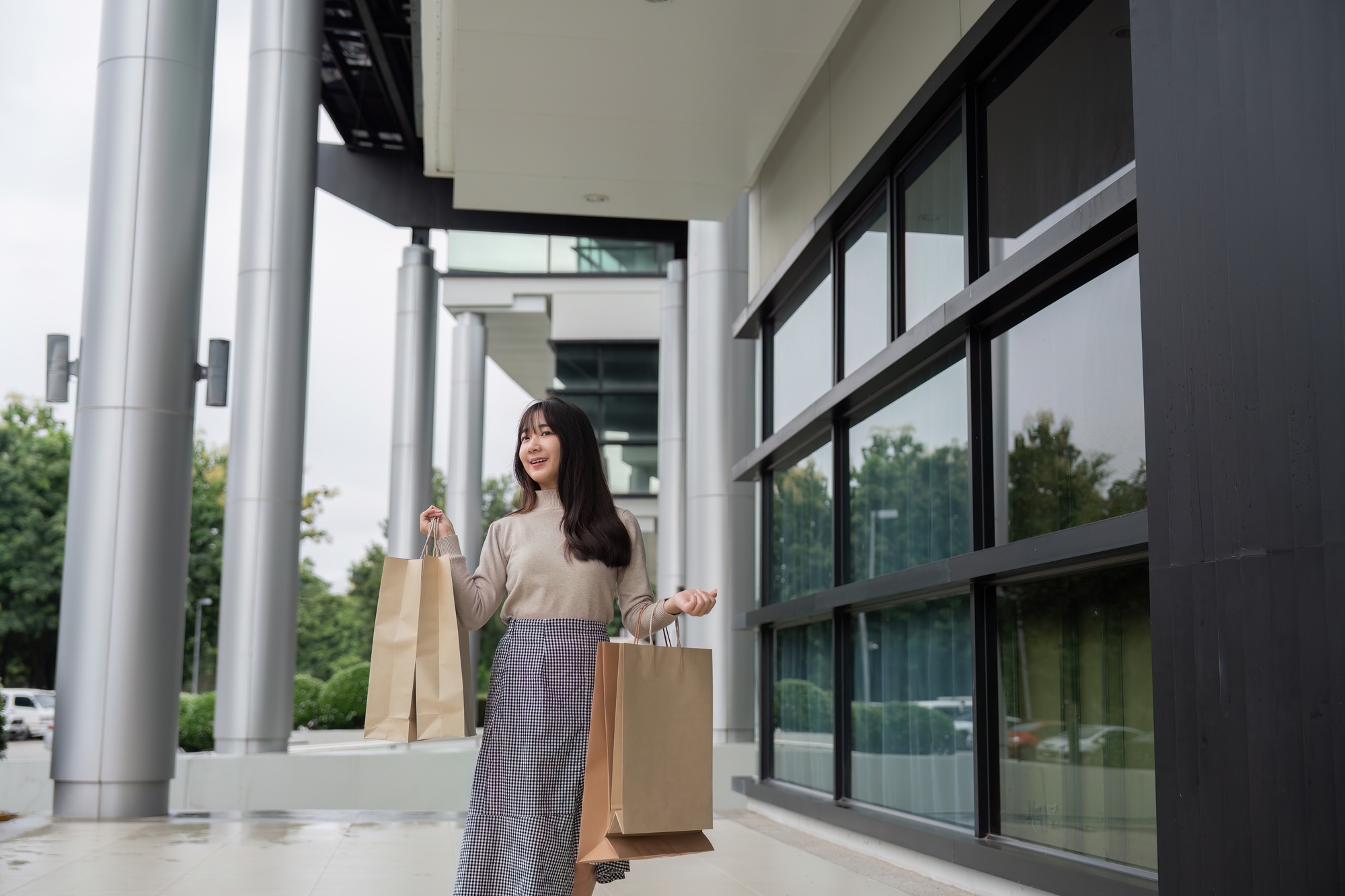 Excited Shopper Holding Bags on Black Friday Outside Modern Shopping Mall