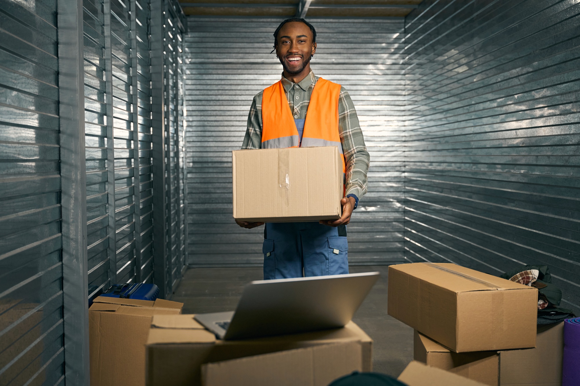 Joyous loader posing for camera at work in storage facility