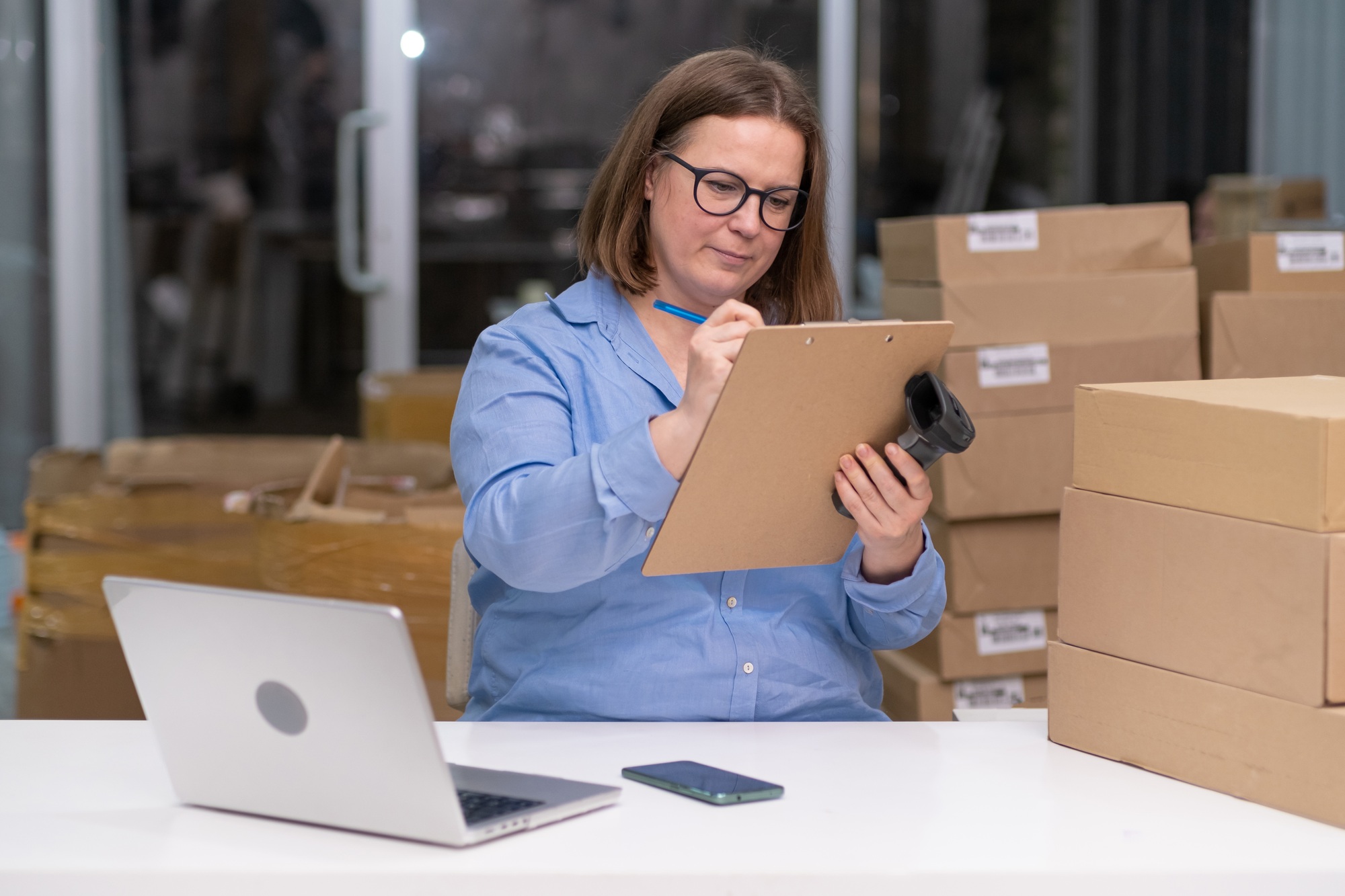 online sales to warehouse delivery: A dropshipping business woma laptop, checking shipping pakage,