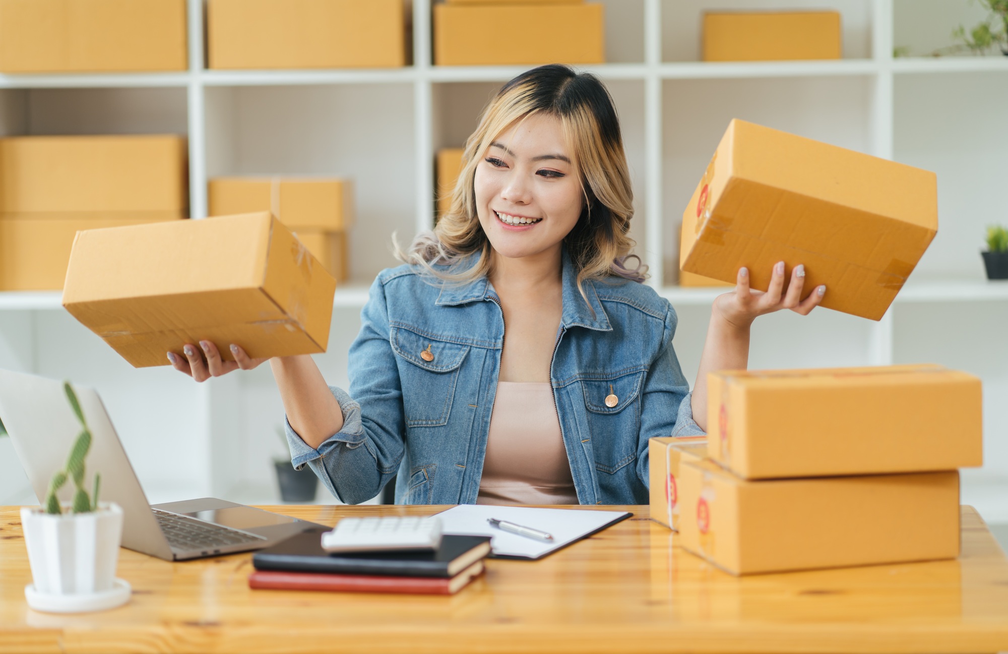 Portrait young attractive asia female owner startup business work happy with box at home prepare par