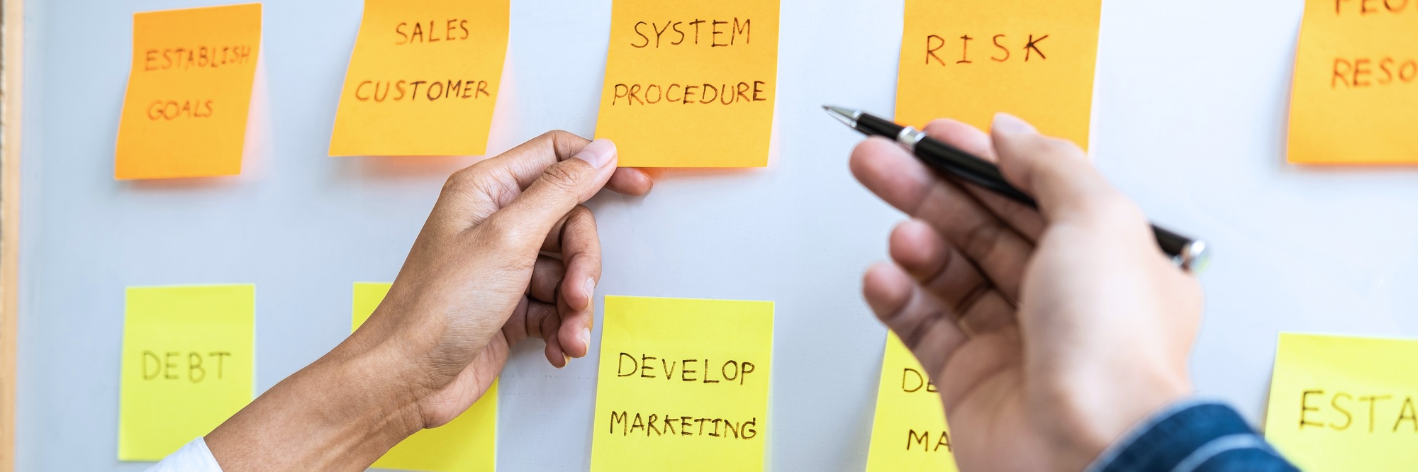 Two creative Business people meeting and planning use post it note on board to share idea