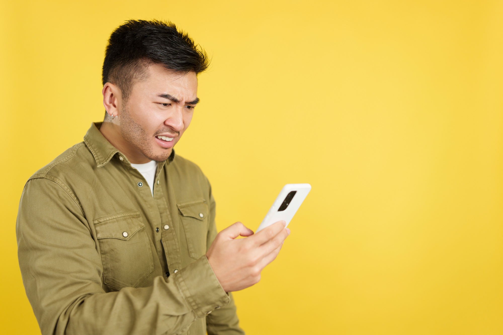 Worried chinese man using a mobile phone