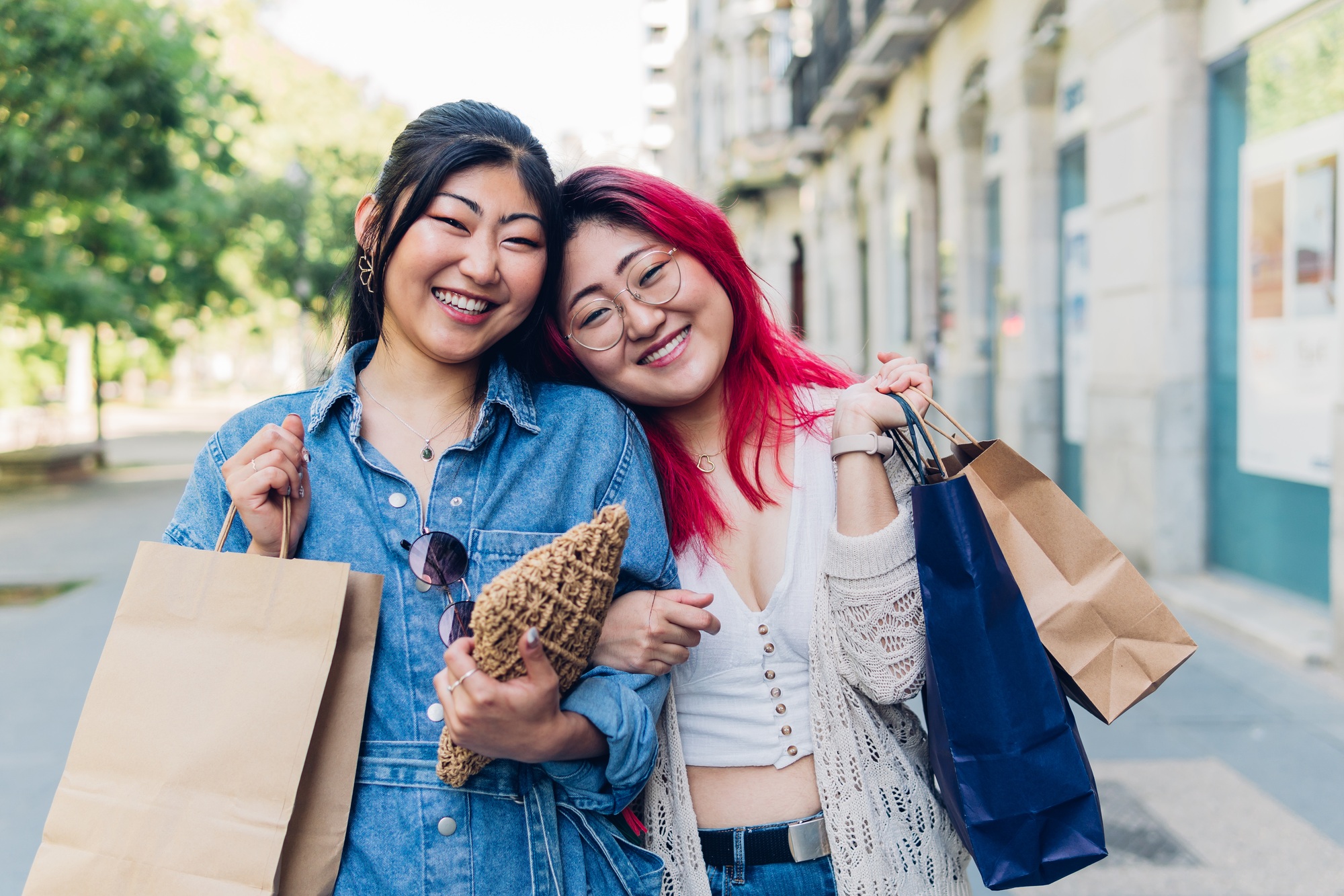 Young asian women looking at camera with shopping bags.