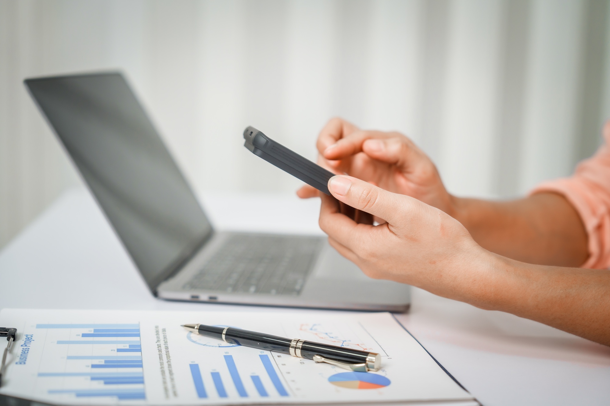 A close-up of a businesswoman working on a laptop in an office. As an accountant,records financial