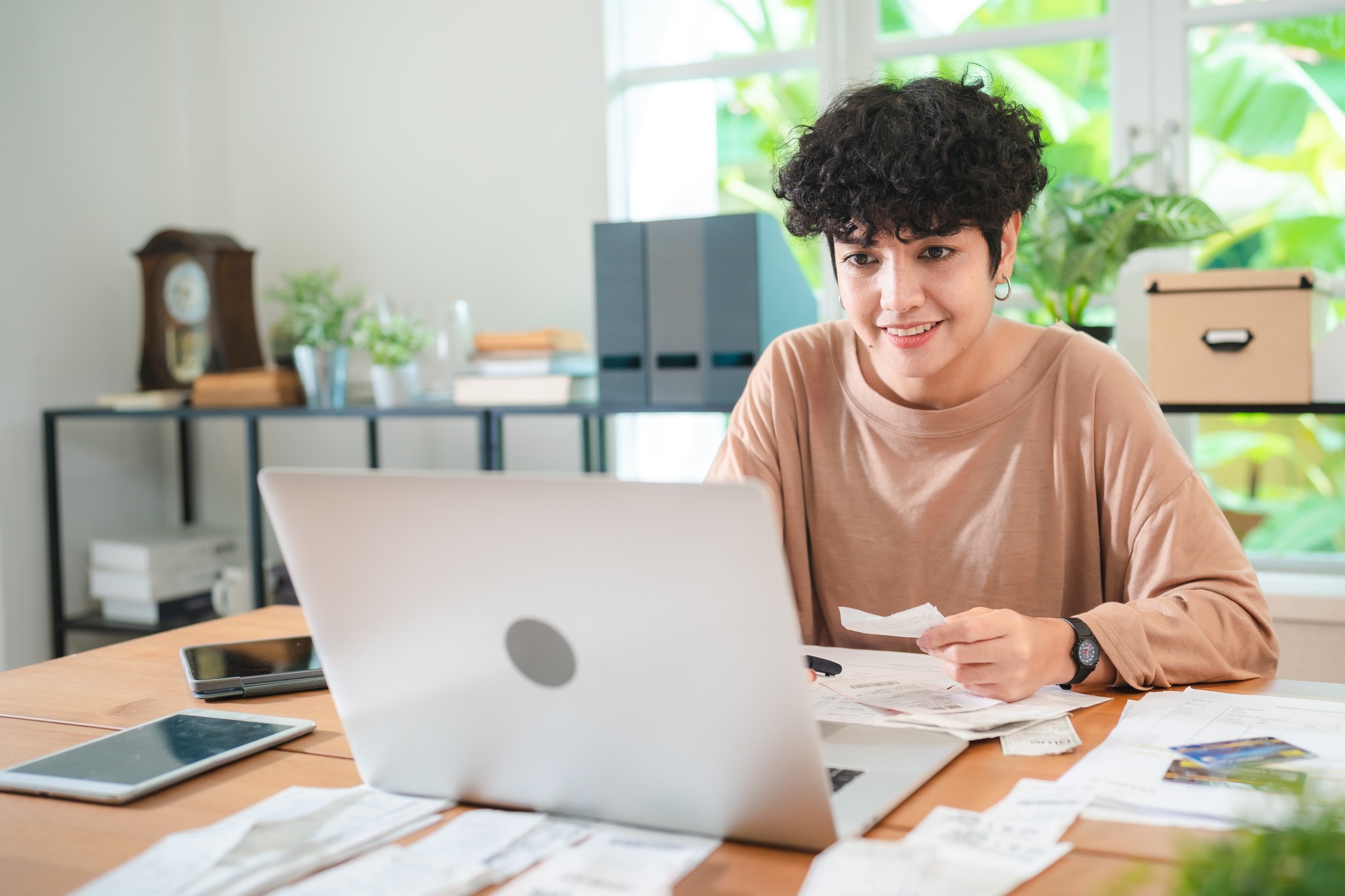 A Young Asian businesswoman is checking financial documents, calculating bills or taxes