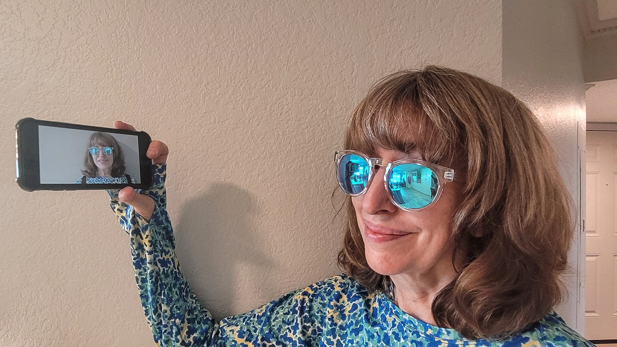 Active baby boomer business professional taking social media profile photo at home.