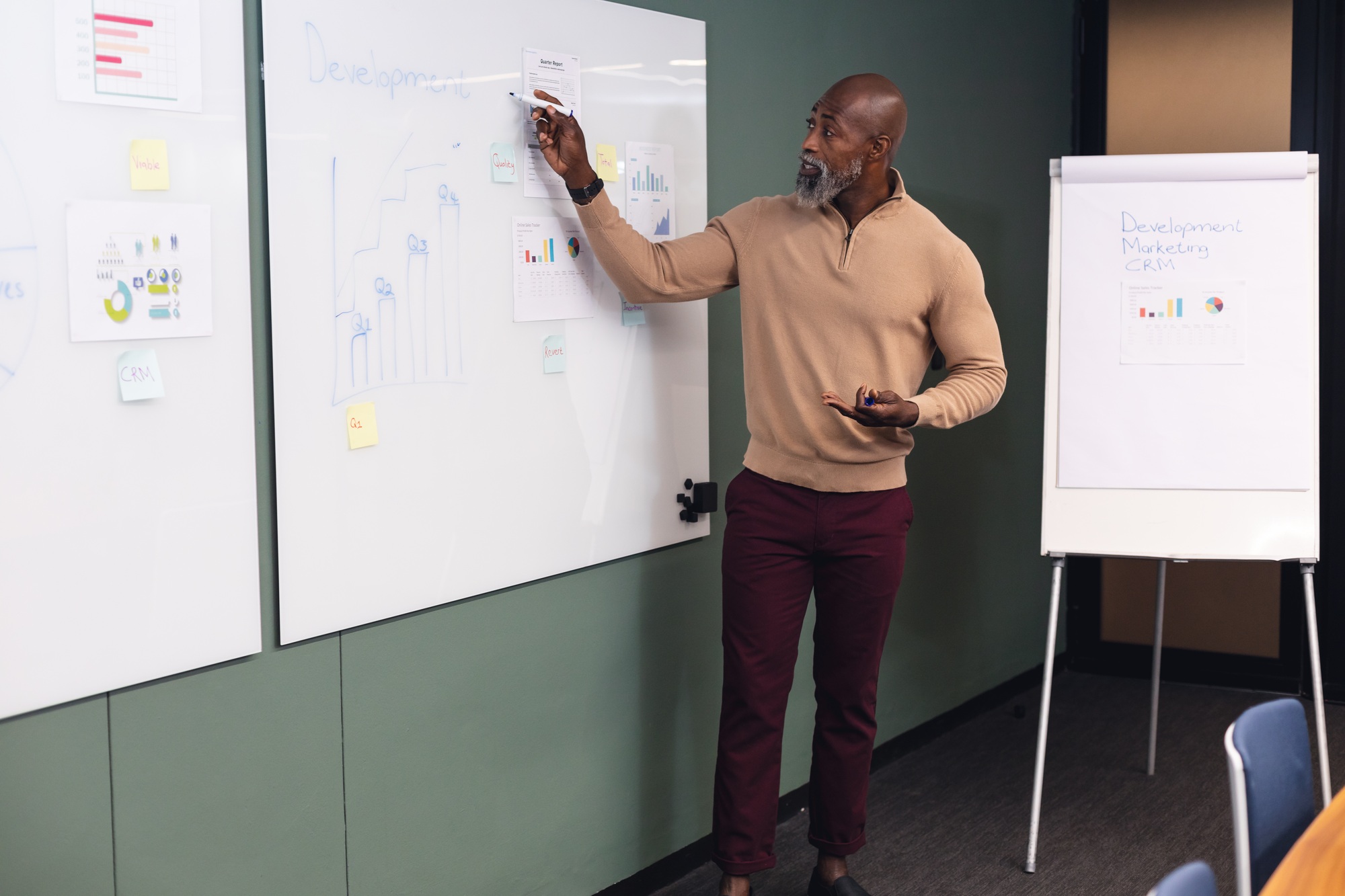 African american mature businessman explaining business strategy over data