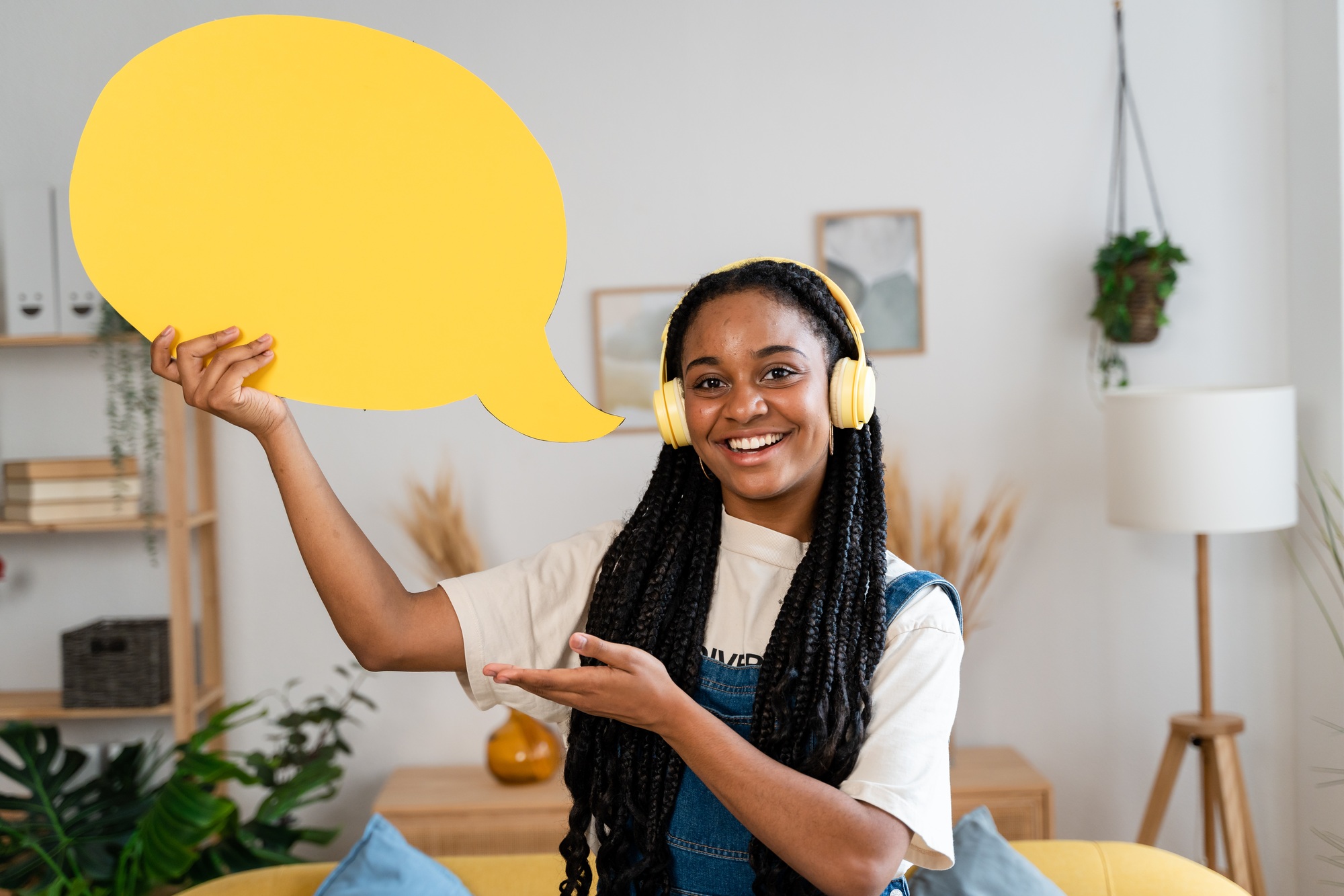 African american woman holding yellow text cloud.