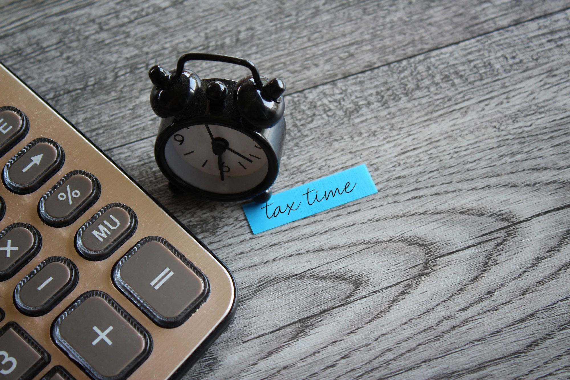Alarm clock and calculator with text TAX TIME.