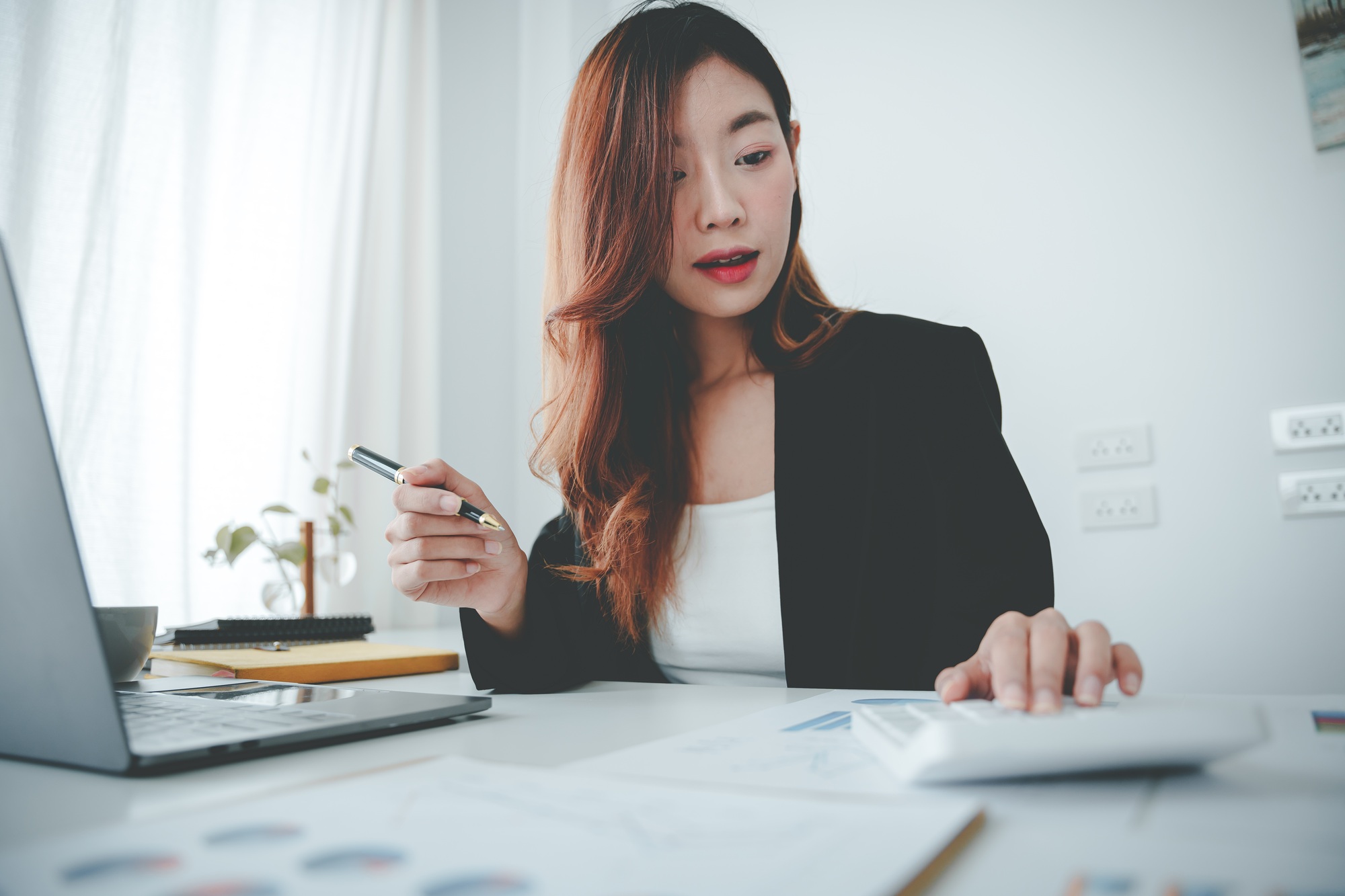 Asian woman working on customer documents, finance, accounting, taxes in the office.
