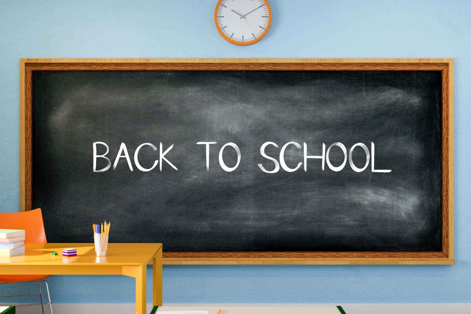 Back to school text written on a blackboard in the classroom.