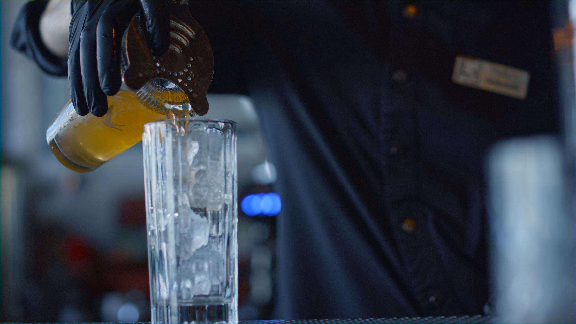 Bartender adding juice cocktail with ice closeup. Mixologist making beverage
