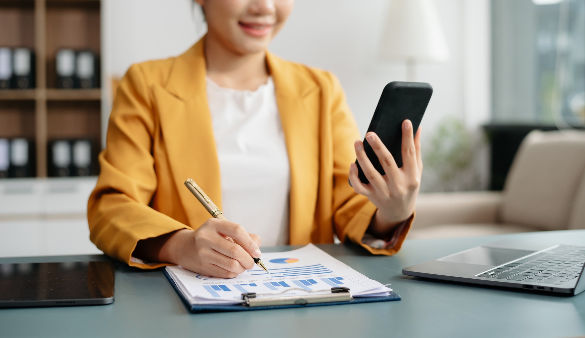 Businesswoman hand using laptop, tablet and smartphone in office. Digital marketing media mobile app