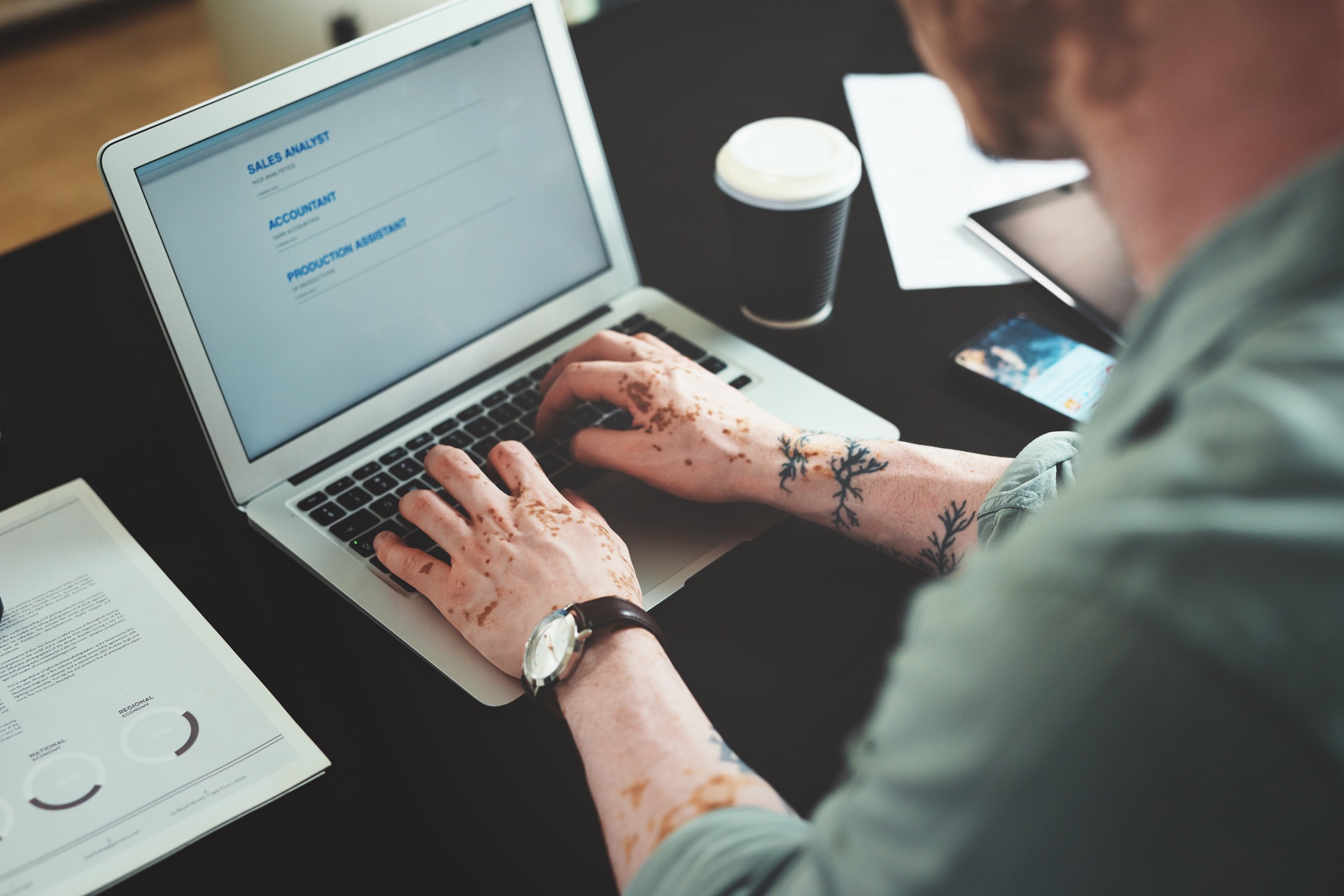 Checking for new job posts. Shot of a young businessman using a laptop in an office at work.