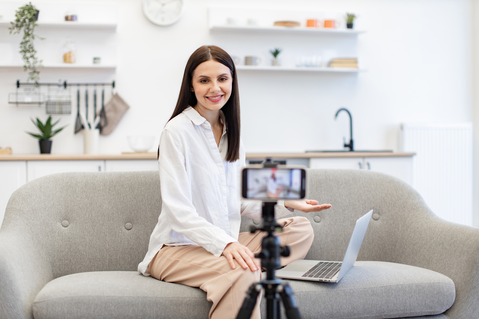 Cheerful content maker recording video to followers on modern smartphone.