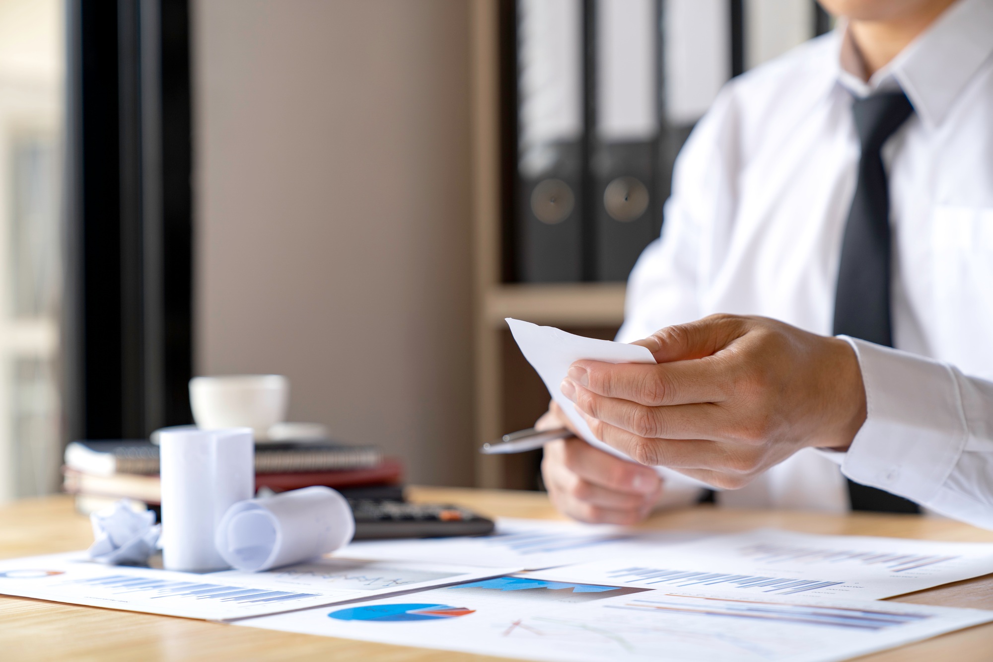 Close-up of businessman's hands collecting bills for tax refund and tax savings, finance banking and