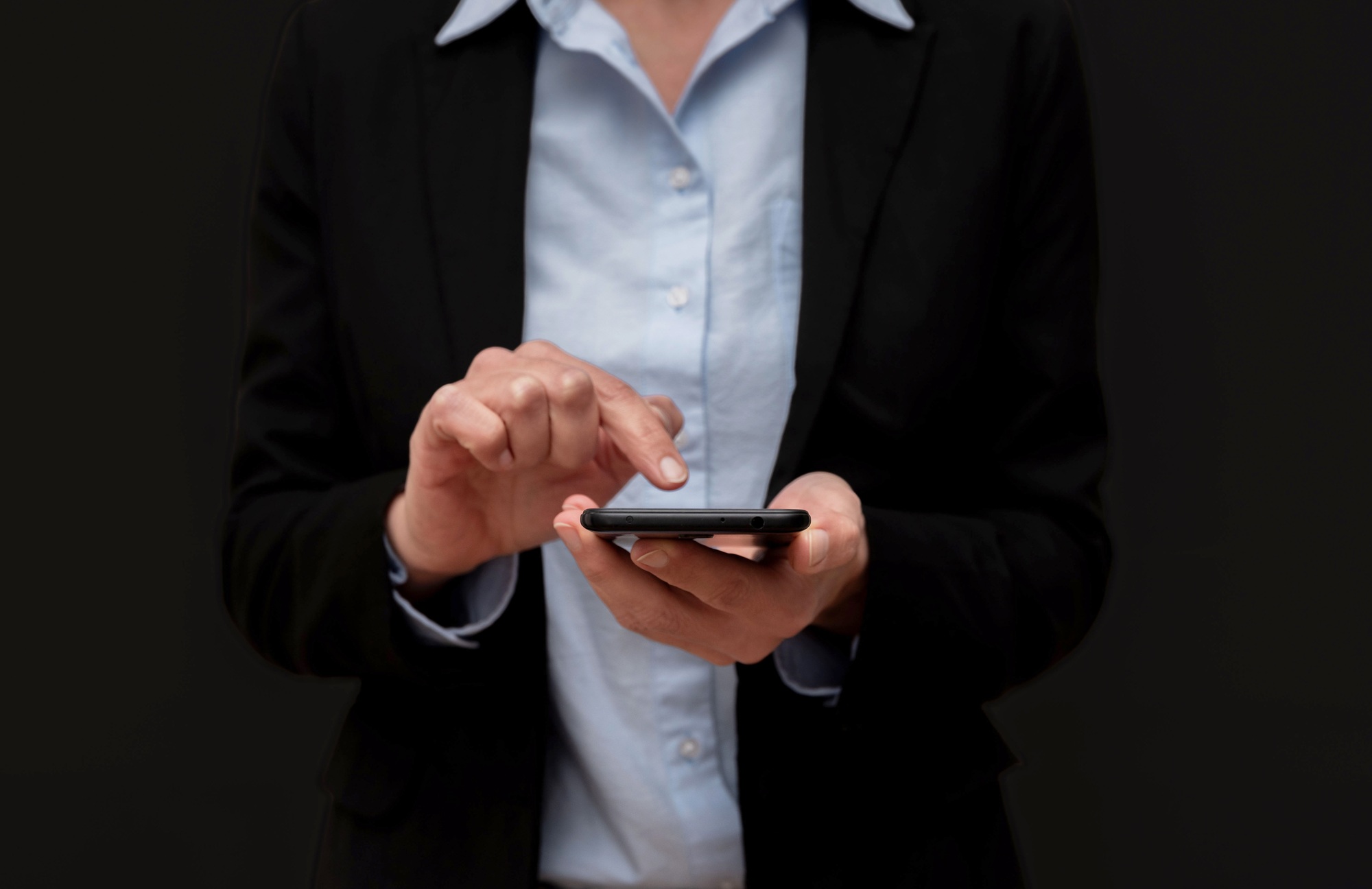 Close up of Businesswoman using smartphone,browsing internet,checking email on black background