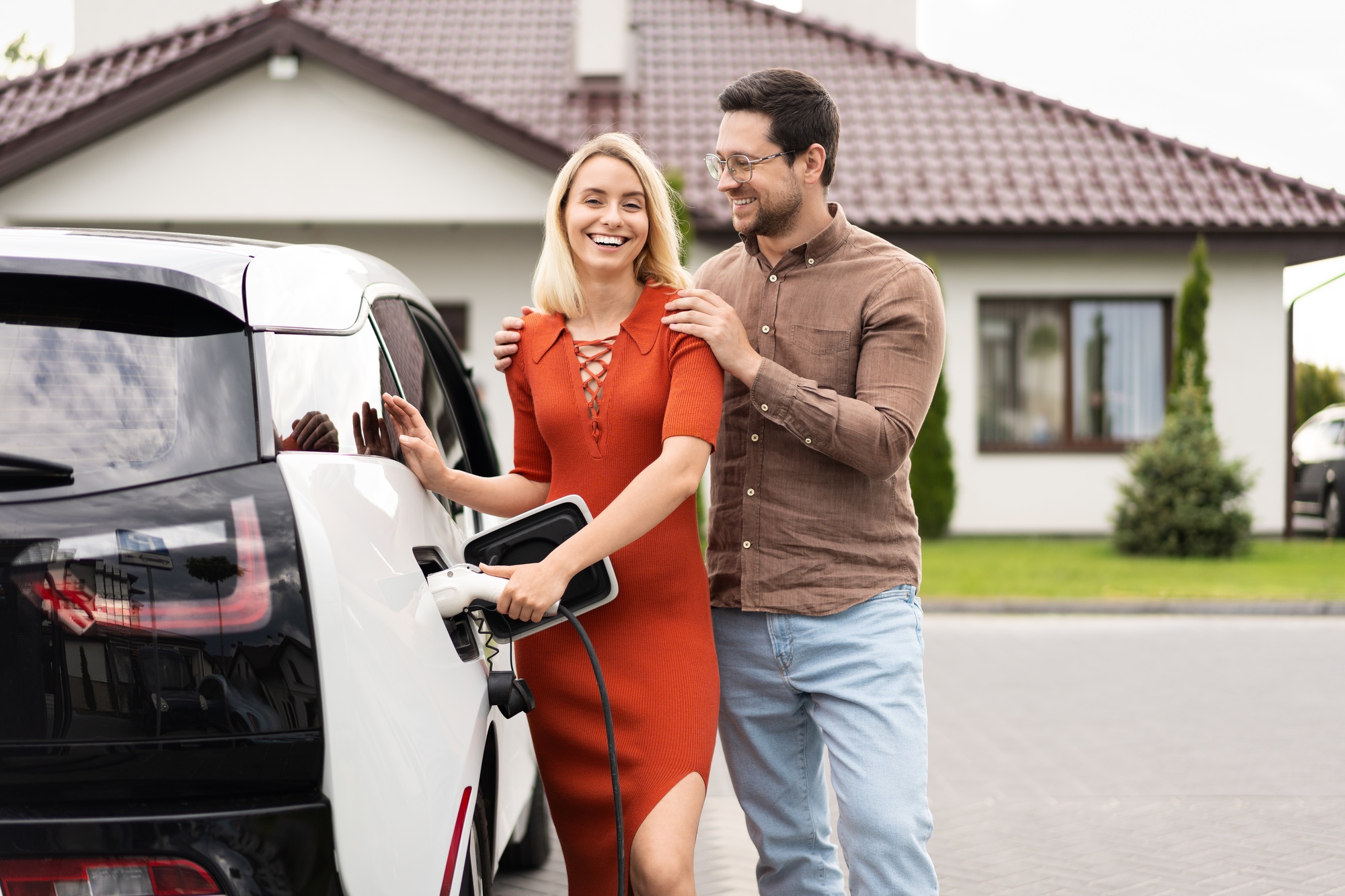 Couple Charging Electric Car at Home, Embracing Sustainable Living