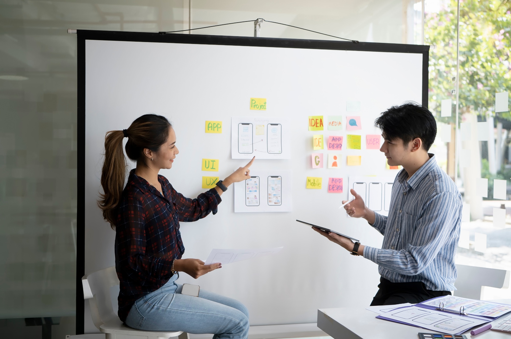 Creative web designers brainstorming and developing template layout, framework for mobile phone.