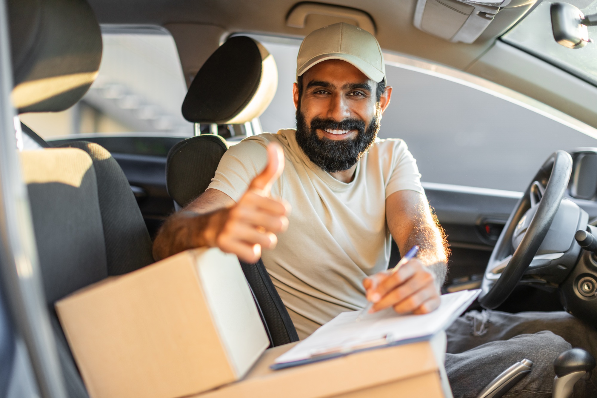 Delivery Driver Giving a Thumbs Up in Car During Daytime