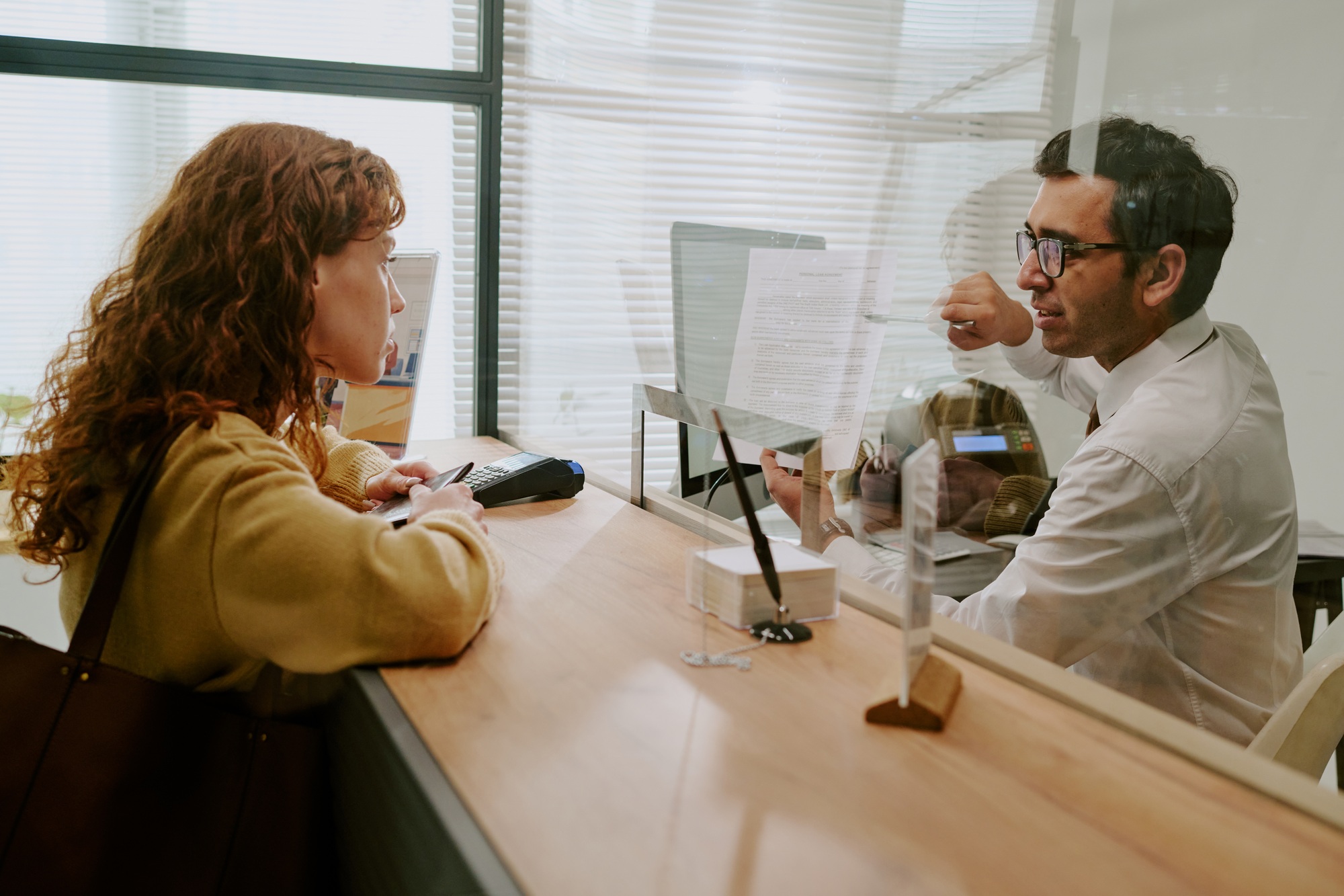 Discussing Clients Needs with Bank Consultant in Office Environment