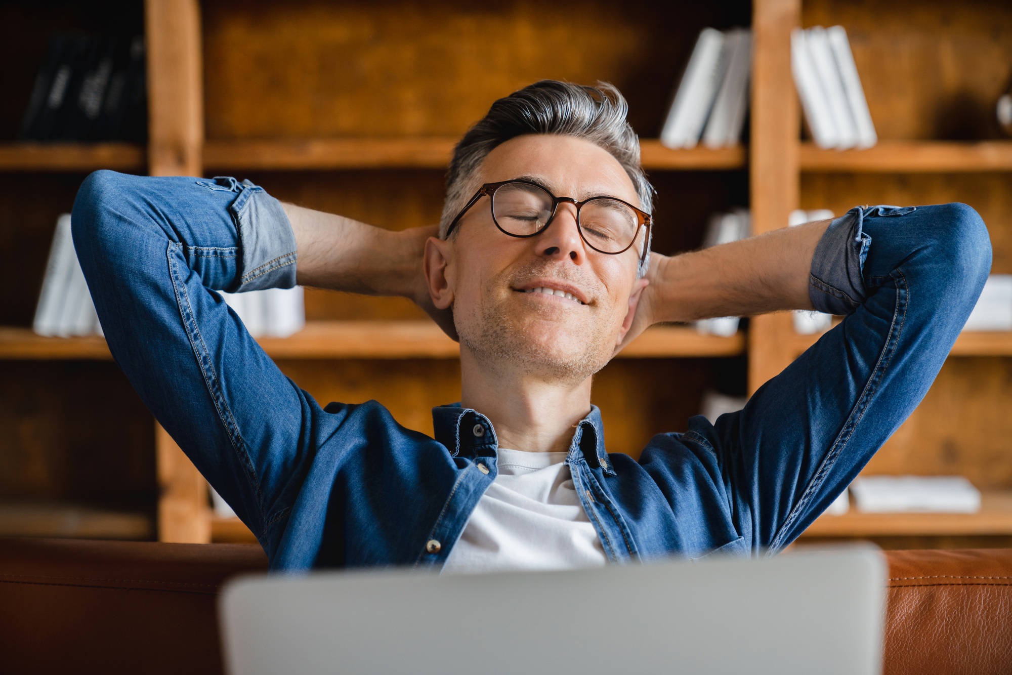 Employee resting while working on laptop, e-learning, dreaming about vacation in office