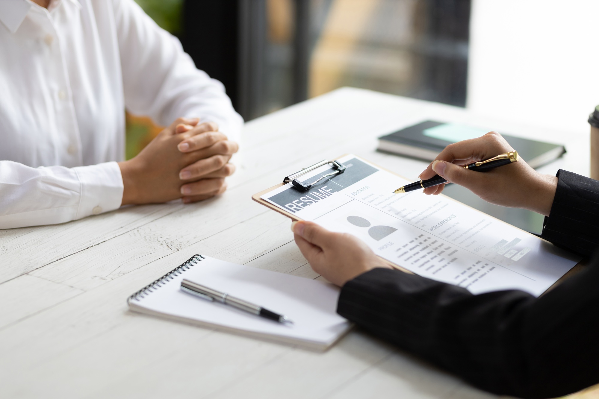 Employer in suit reading resume of job interview candidate profile collection.