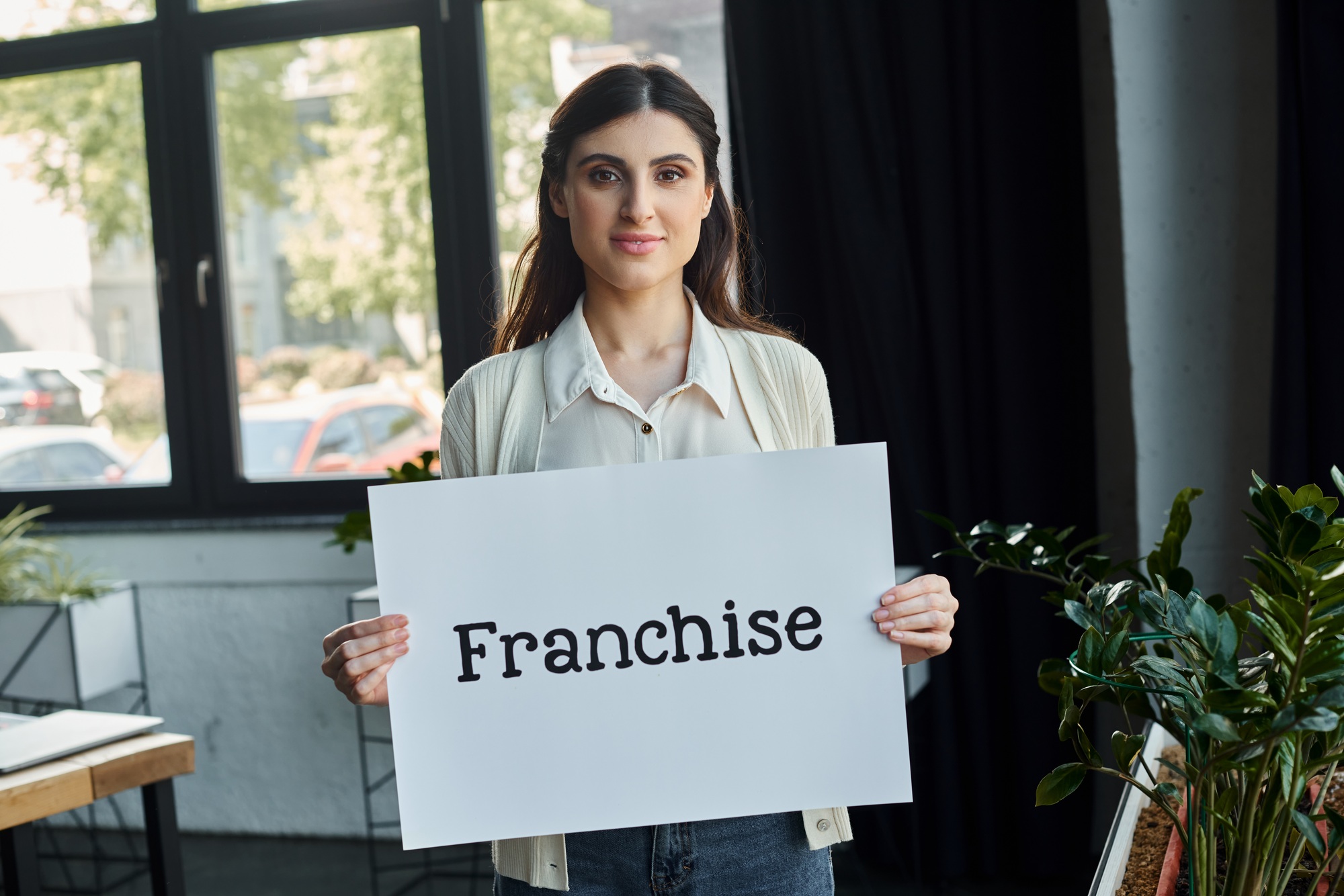 Empowered businesswoman holding franchise sign