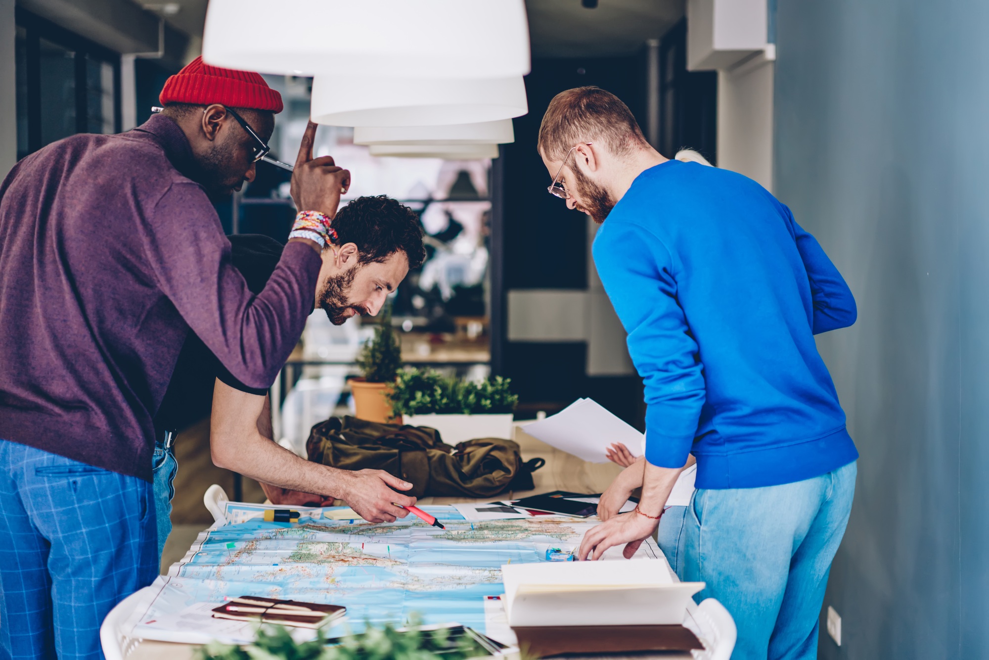 Group of friends navigating on paper map at home
