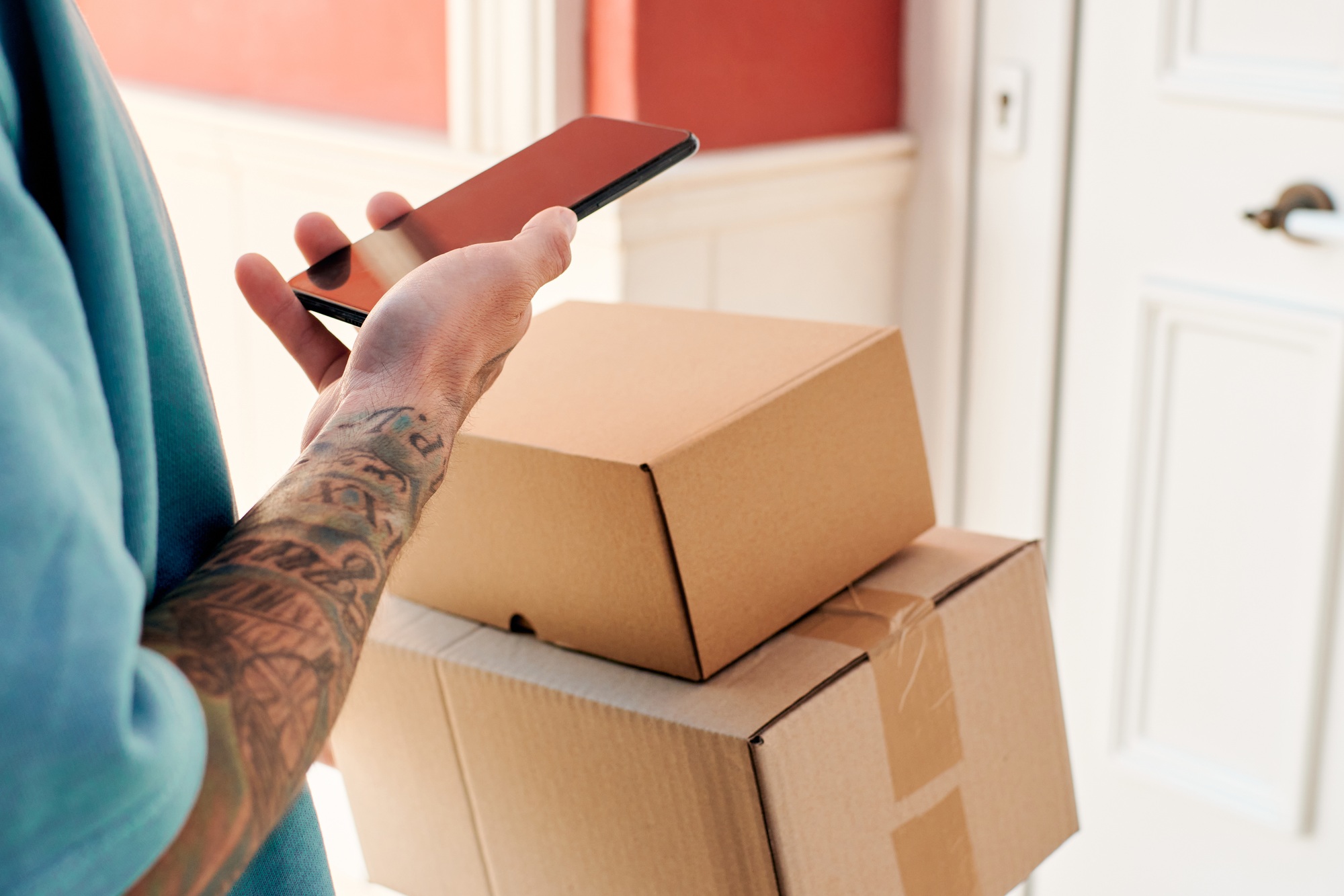Letter carrier checks an order with his mobile phone