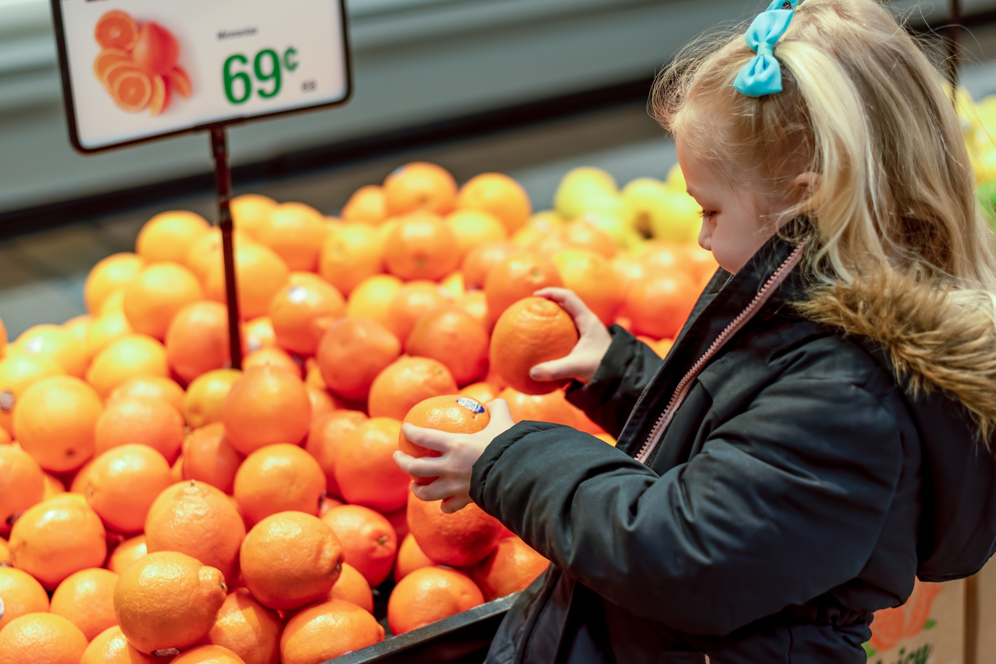 Little girl choosing fruit at the grocery store