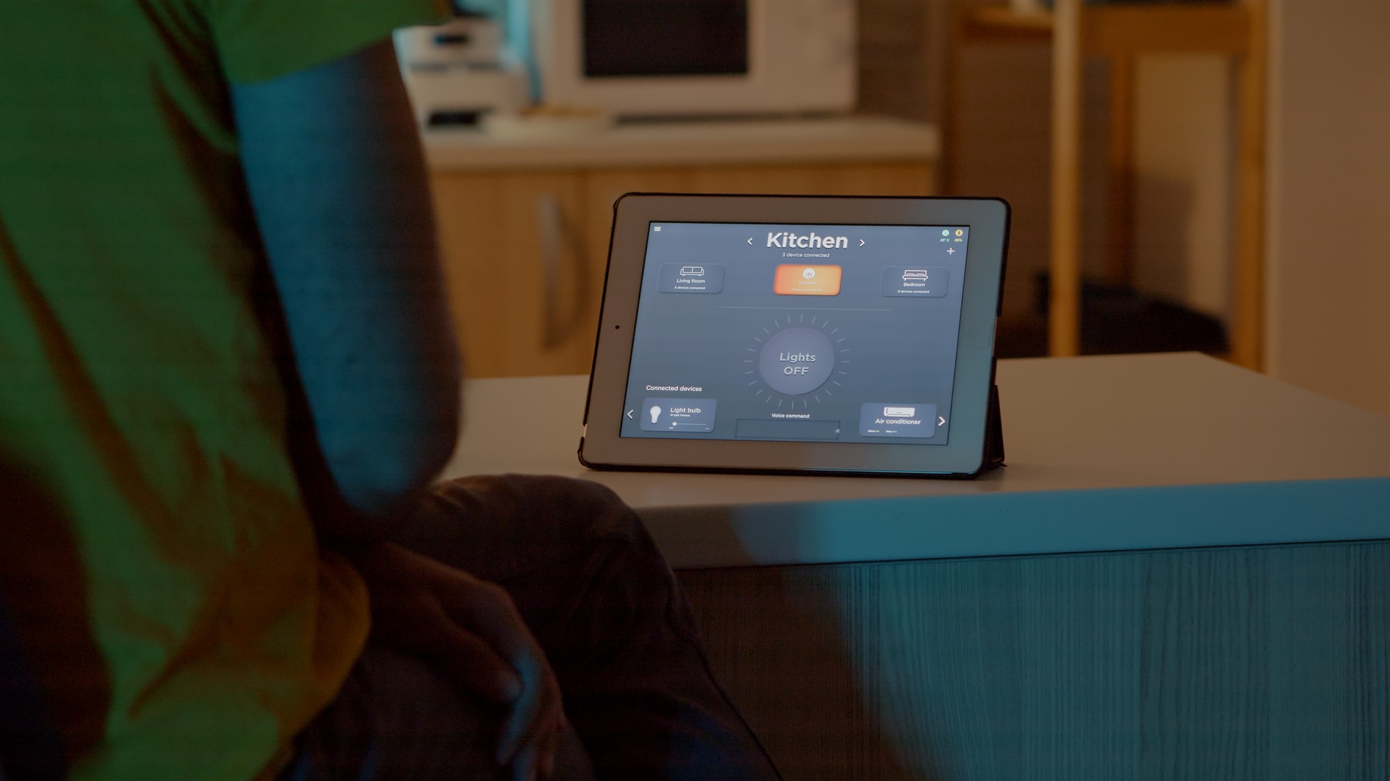 Man switching on bulbs using voice command on tablet