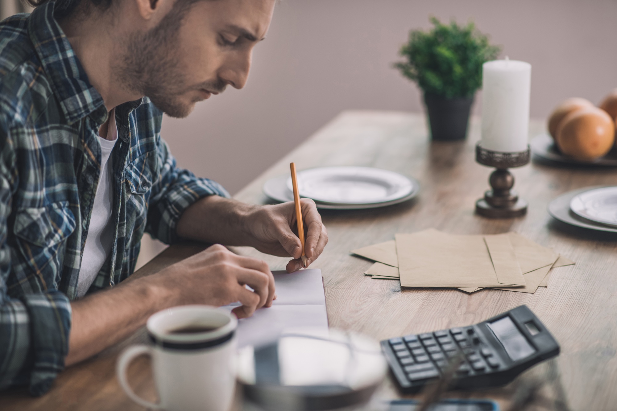 Man writing and calculating the pros and cons of his business idea